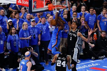 May 18, 2026; Oklahoma City, Oklahoma, USA; Oklahoma City Thunder guard Shai Gilgeous-Alexander (2) dunks the ball while defended by San Antonio Spurs center Victor Wembanyama (1) during overtime in game one of the western conference finals for the 2026 NBA playoffs at Paycom Center. Mandatory Credit: Alonzo Adams-Imagn Images
