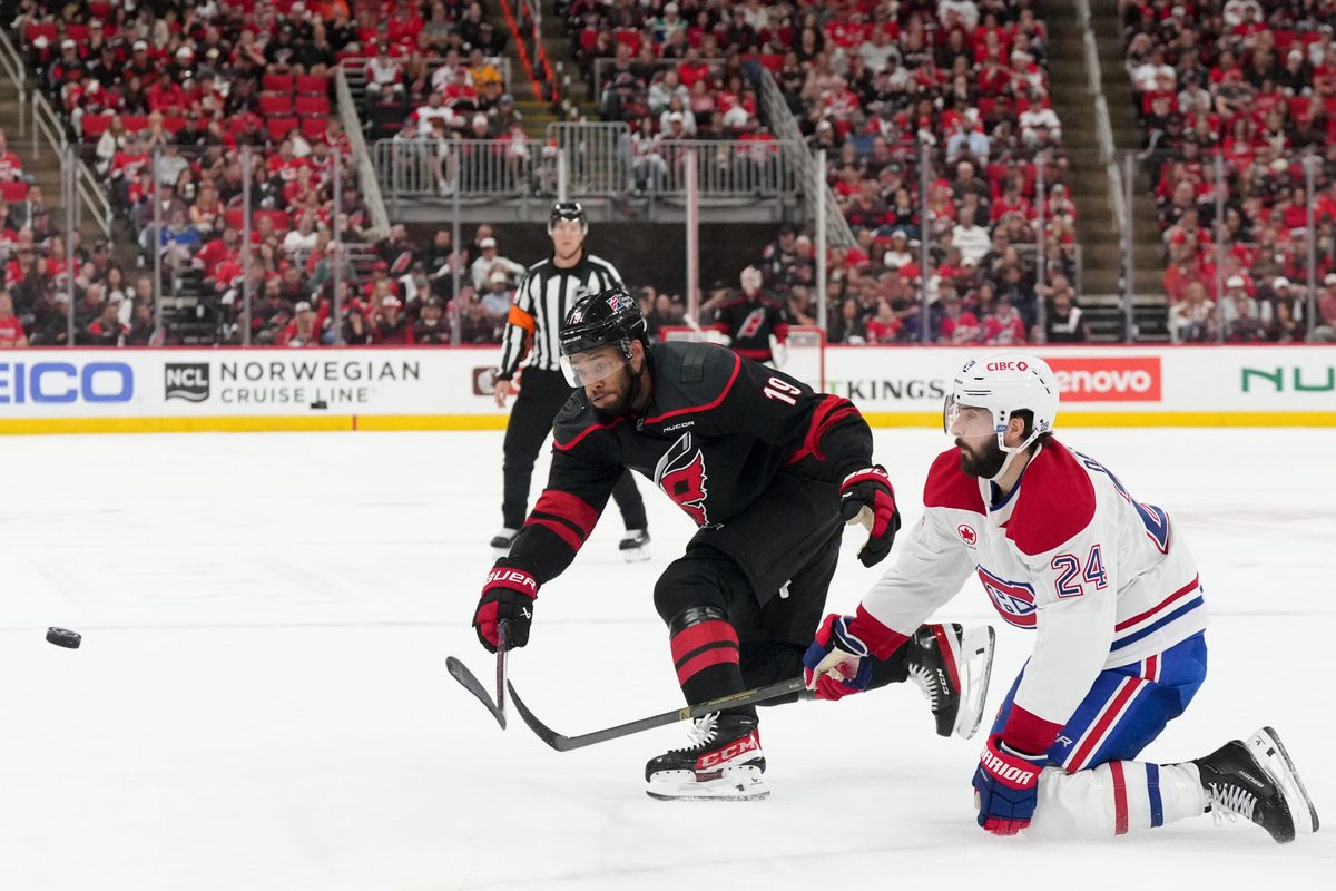 May 21, 2026; Raleigh, North Carolina, USA; Carolina Hurricanes defenseman K'andre Miller (19) passes the puck defended by Montreal Canadiens center Phillip Danault (24) during the third period in game one of the Eastern Conferene Final of the 2026 Stanley Cup Playoffs at Lenovo Center. Mandatory Credit: James Guillory-Imagn Images