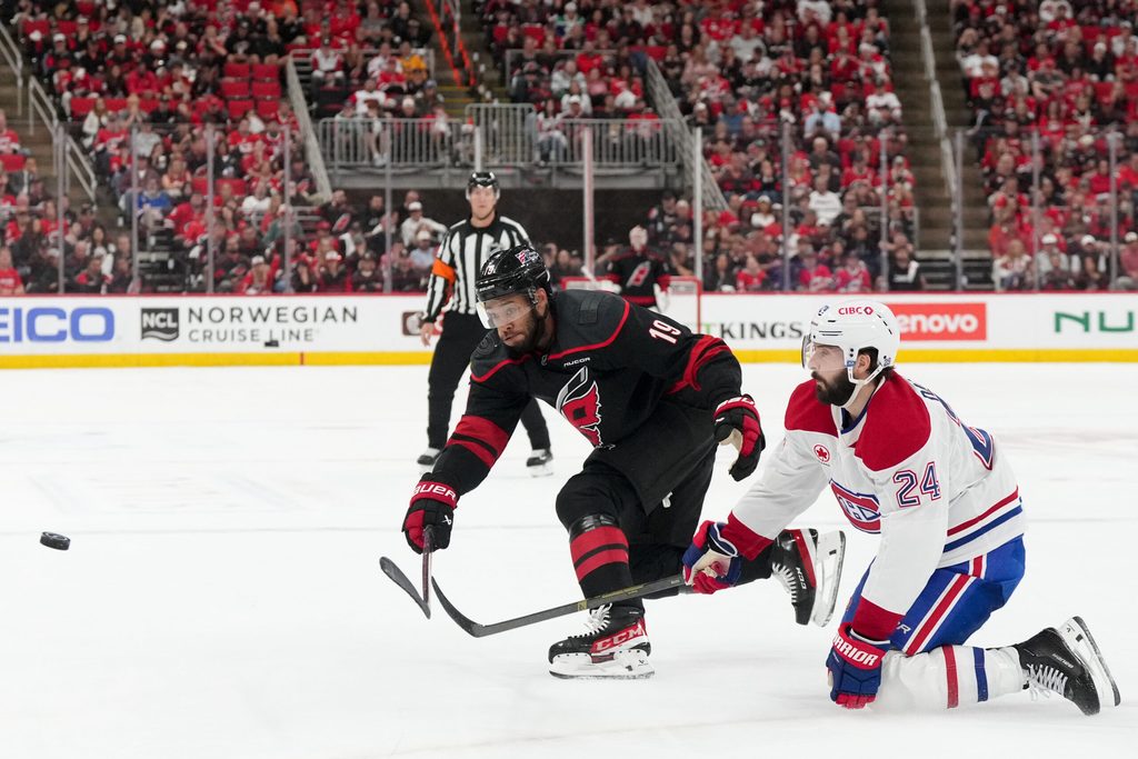 May 21, 2026; Raleigh, North Carolina, USA; Carolina Hurricanes defenseman K'andre Miller (19) passes the puck defended by Montreal Canadiens center Phillip Danault (24) during the third period in game one of the Eastern Conferene Final of the 2026 Stanley Cup Playoffs at Lenovo Center. Mandatory Credit: James Guillory-Imagn Images