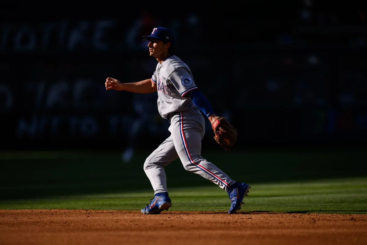 May 24, 2026; Anaheim, California, USA; Texas Rangers second baseman Justin Foscue (14) chases a ball during the sixth inning against the Los Angeles Angels at Angel Stadium. Mandatory Credit: William Liang-Imagn Images