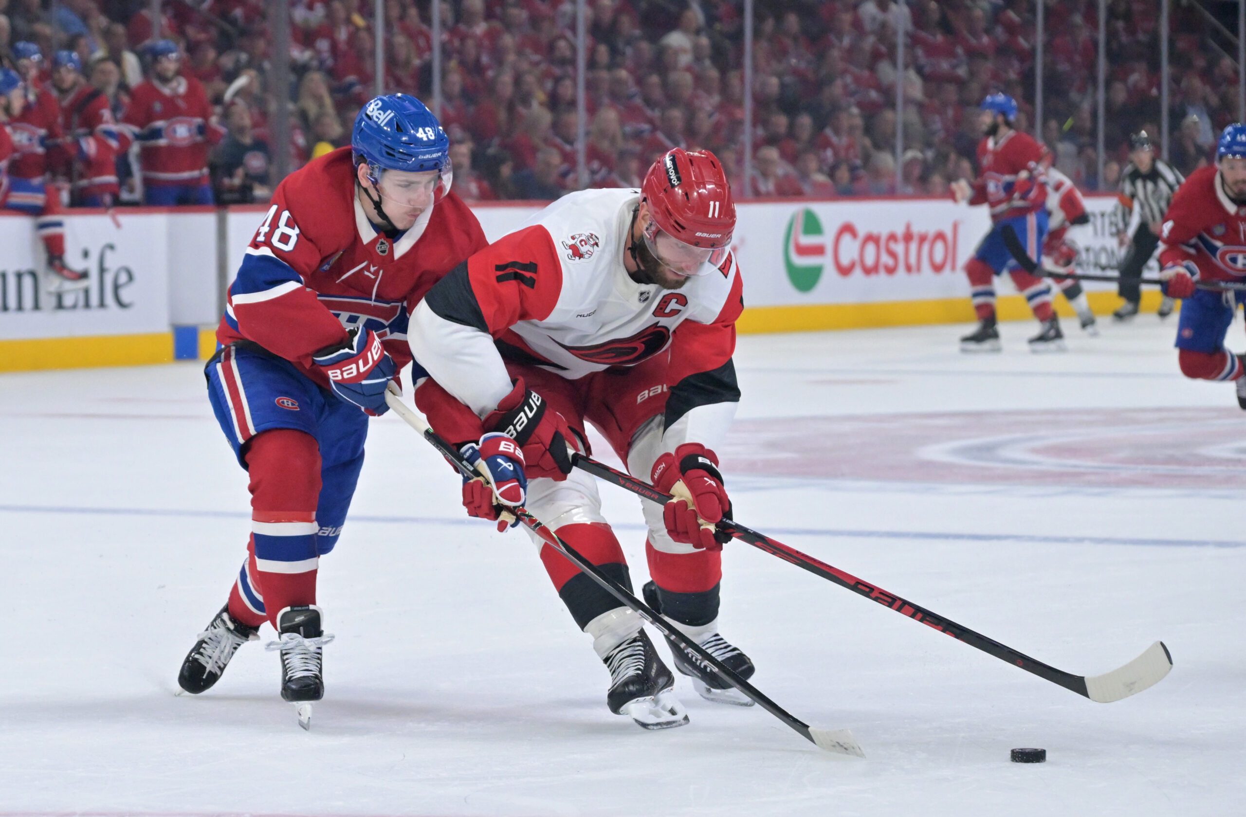 May 25, 2026; Montreal, Quebec, CAN; Montreal Canadiens defenseman Lane Hutson (48) and Carolina Hurricanes center Jordan Staal (11) battle for the puck during the second period in game three of the Eastern Conference Final of the 2026 Stanley Cup Playoffs at Bell Centre. Mandatory Credit: Eric Bolte-Imagn Images