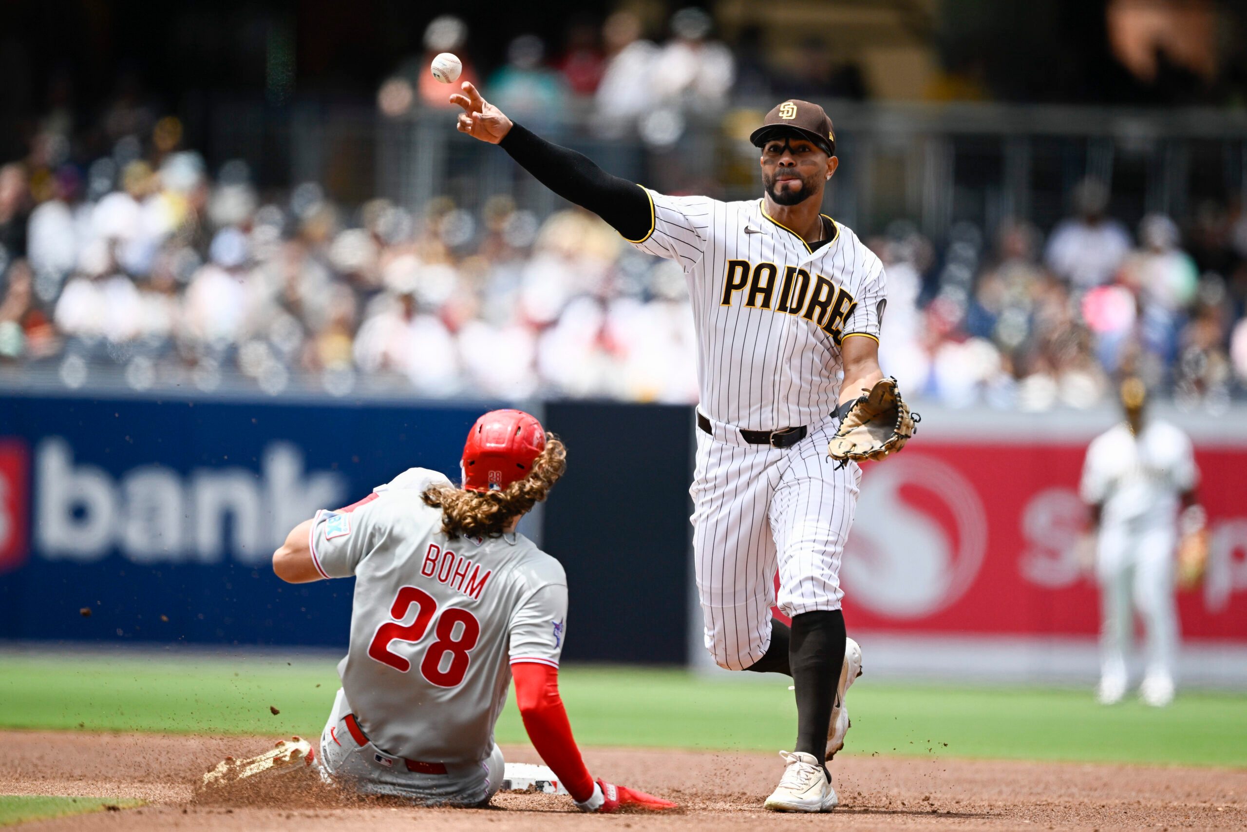 May 27, 2026; San Diego, California, USA; San Diego Padres shortstop Xander Bogaerts (2) throws over Philadelphia Phillies third baseman Alec Bohm (28) as he turns a double play during the second inning at Petco Park. Mandatory Credit: Denis Poroy-Imagn Images