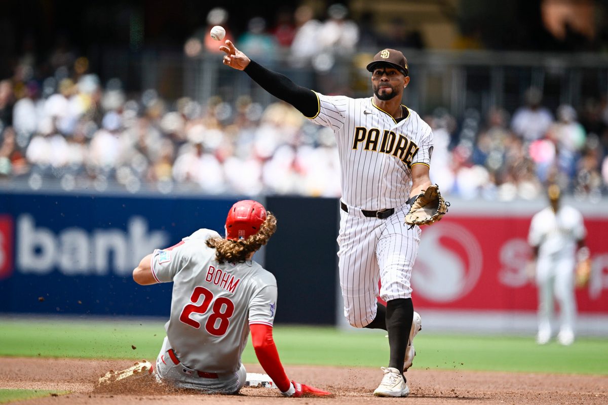 May 27, 2026; San Diego, California, USA; San Diego Padres shortstop Xander Bogaerts (2) throws over Philadelphia Phillies third baseman Alec Bohm (28) as he turns a double play during the second inning at Petco Park. Mandatory Credit: Denis Poroy-Imagn Images