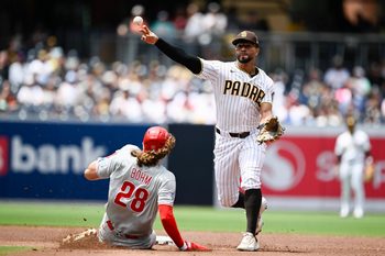 May 27, 2026; San Diego, California, USA; San Diego Padres shortstop Xander Bogaerts (2) throws over Philadelphia Phillies third baseman Alec Bohm (28) as he turns a double play during the second inning at Petco Park. Mandatory Credit: Denis Poroy-Imagn Images