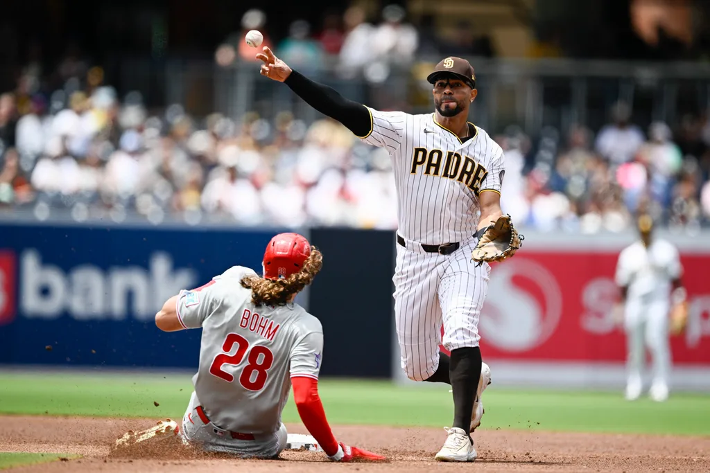 May 27, 2026; San Diego, California, USA; San Diego Padres shortstop Xander Bogaerts (2) throws over Philadelphia Phillies third baseman Alec Bohm (28) as he turns a double play during the second inning at Petco Park. Mandatory Credit: Denis Poroy-Imagn Images