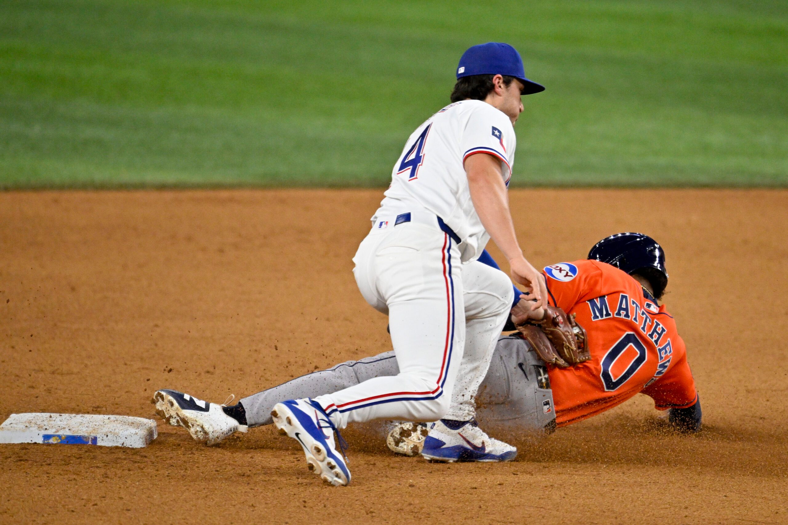 May 27, 2026; Arlington, Texas, USA;  Texas Rangers second baseman Justin Foscue (14) tags out Houston Astros second baseman Brice Matthews (0) during the ninth inning at Globe Life Field. Mandatory Credit: Jerome Miron-Imagn Images