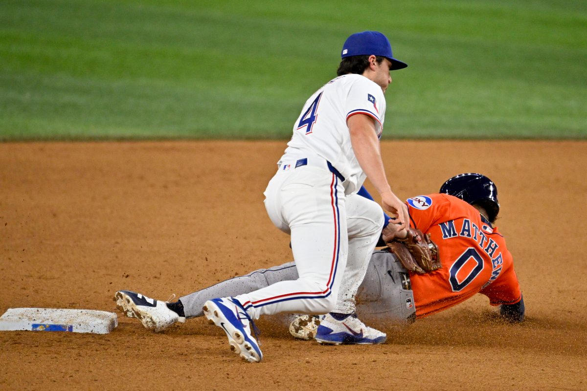 May 27, 2026; Arlington, Texas, USA;  Texas Rangers second baseman Justin Foscue (14) tags out Houston Astros second baseman Brice Matthews (0) during the ninth inning at Globe Life Field. Mandatory Credit: Jerome Miron-Imagn Images