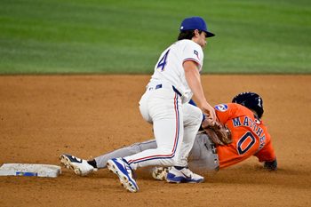 May 27, 2026; Arlington, Texas, USA;  Texas Rangers second baseman Justin Foscue (14) tags out Houston Astros second baseman Brice Matthews (0) during the ninth inning at Globe Life Field. Mandatory Credit: Jerome Miron-Imagn Images