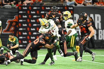 Jun 7, 2025; Vancouver, British Columbia, Canada;  BC Lions wide receiver Ezecheil Tieide (80) tackles Edmonton Elks wide receiver Arkell Smith (86) during the second half at BC Place Stadium. Mandatory Credit: Anne-Marie Sorvin-Imagn Images