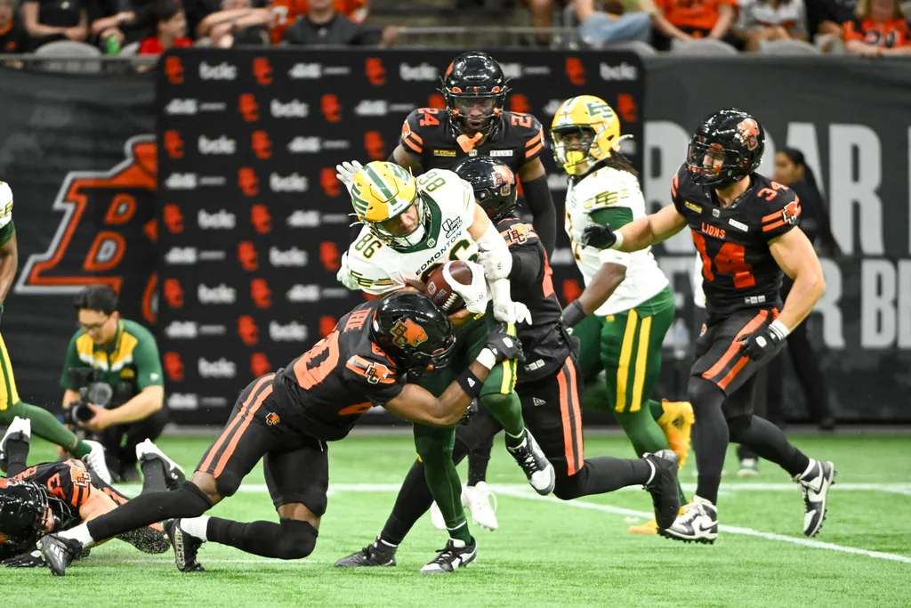 Jun 7, 2025; Vancouver, British Columbia, Canada; BC Lions wide receiver Ezecheil Tieide (80) tackles Edmonton Elks wide receiver Arkell Smith (86) during the second half at BC Place Stadium. Mandatory Credit: Anne-Marie Sorvin-Imagn Images