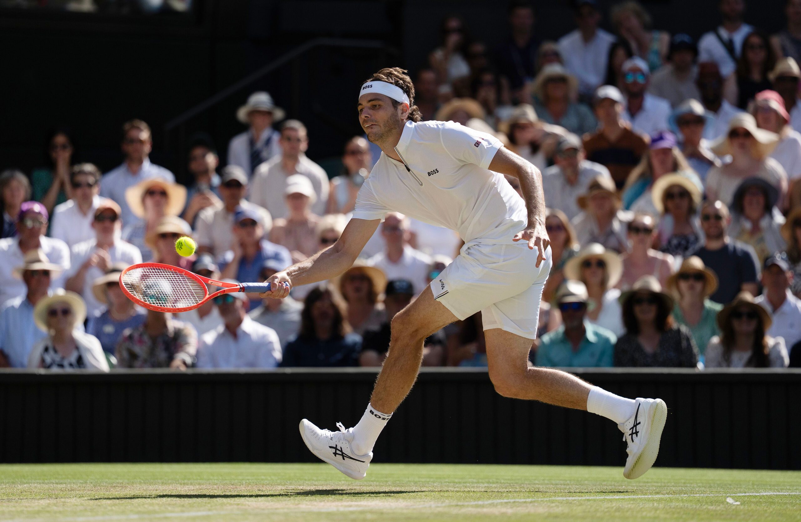 Jul 11, 2025; Wimbledon, United Kingdom; Taylor Fritz of the United States returns a shot during his match against Carlos Alcaraz of Spain on day 12 at All England Lawn Tennis and Croquet Club. Mandatory Credit: Susan Mullane-Imagn Images