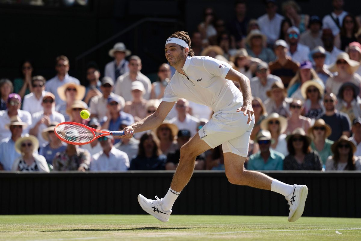 Jul 11, 2025; Wimbledon, United Kingdom; Taylor Fritz of the United States returns a shot during his match against Carlos Alcaraz of Spain on day 12 at All England Lawn Tennis and Croquet Club. Mandatory Credit: Susan Mullane-Imagn Images