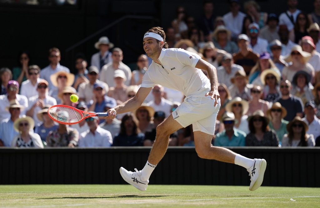 Jul 11, 2025; Wimbledon, United Kingdom; Taylor Fritz of the United States returns a shot during his match against Carlos Alcaraz of Spain on day 12 at All England Lawn Tennis and Croquet Club. Mandatory Credit: Susan Mullane-Imagn Images