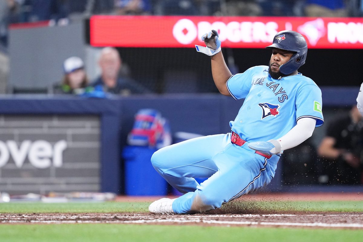 May 24, 2026; Toronto, Ontario, CAN; Toronto Blue Jays first baseman Vladimir Guerrero Jr. (27) slides into home plate scoring a run against the Pittsburgh Pirates during the fourth inning at Rogers Centre. Mandatory Credit: Nick Turchiaro-Imagn Images