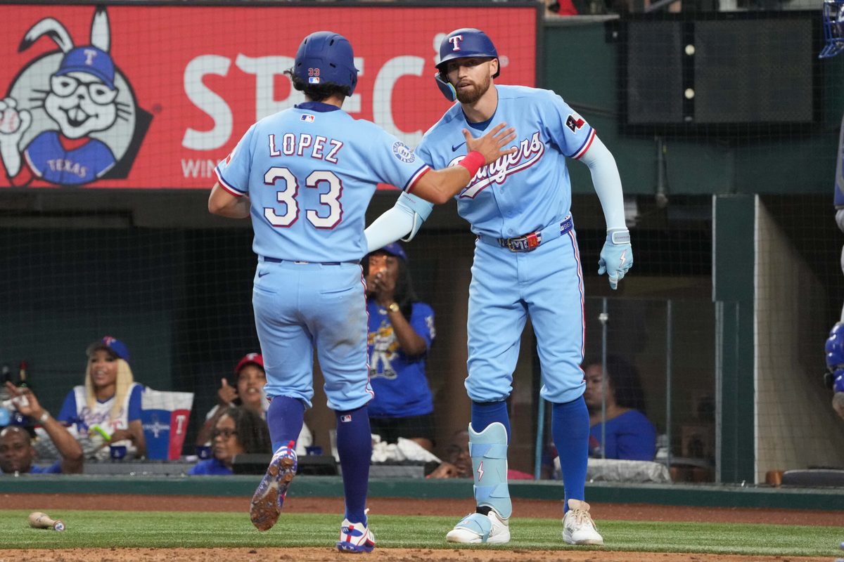 May 31, 2026; Arlington, Texas, USA; Texas Rangers second baseman Nicky Lopez (33) and Brandon Nimmo (24) celebrate scoring against the Kansas City Royals during the fourth inning at Globe Life Field. Mandatory Credit: Jim Cowsert-Imagn Images