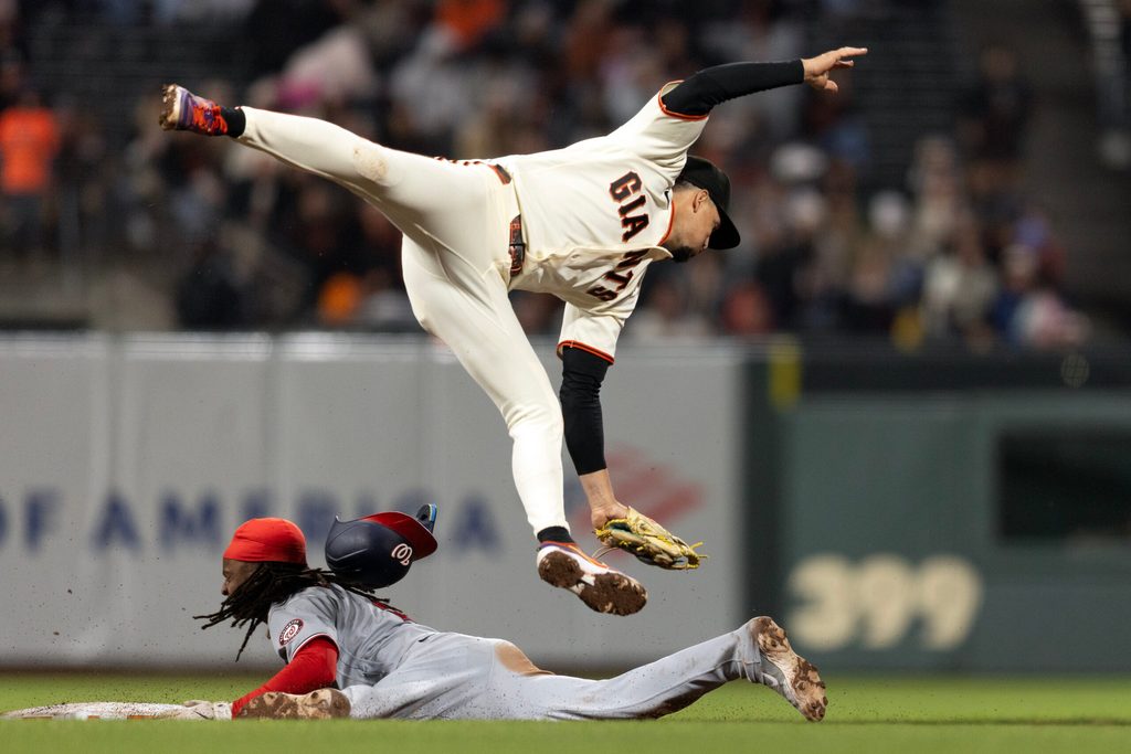 Jun 8, 2026; San Francisco, California, USA; San Francisco Giants shortstop Willy Adames (2) cannot reach an errant throw from the catcher as Washington Nationals shortstop CJ Abrams (5) slides safely into second with a stolen base during the ninth inning at Oracle Park. Mandatory Credit: D. Ross Cameron-Imagn Images
