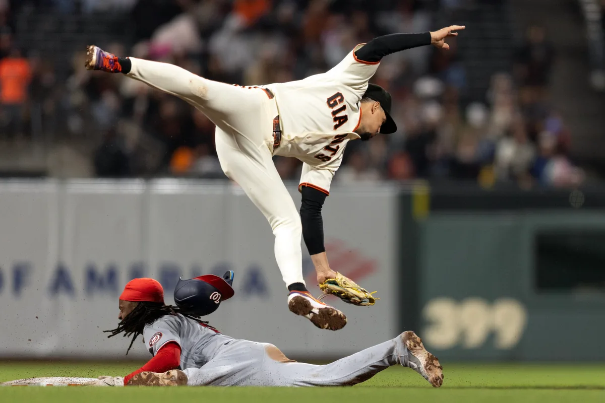 Jun 8, 2026; San Francisco, California, USA; San Francisco Giants shortstop Willy Adames (2) cannot reach an errant throw from the catcher as Washington Nationals shortstop CJ Abrams (5) slides safely into second with a stolen base during the ninth inning at Oracle Park. Mandatory Credit: D. Ross Cameron-Imagn Images