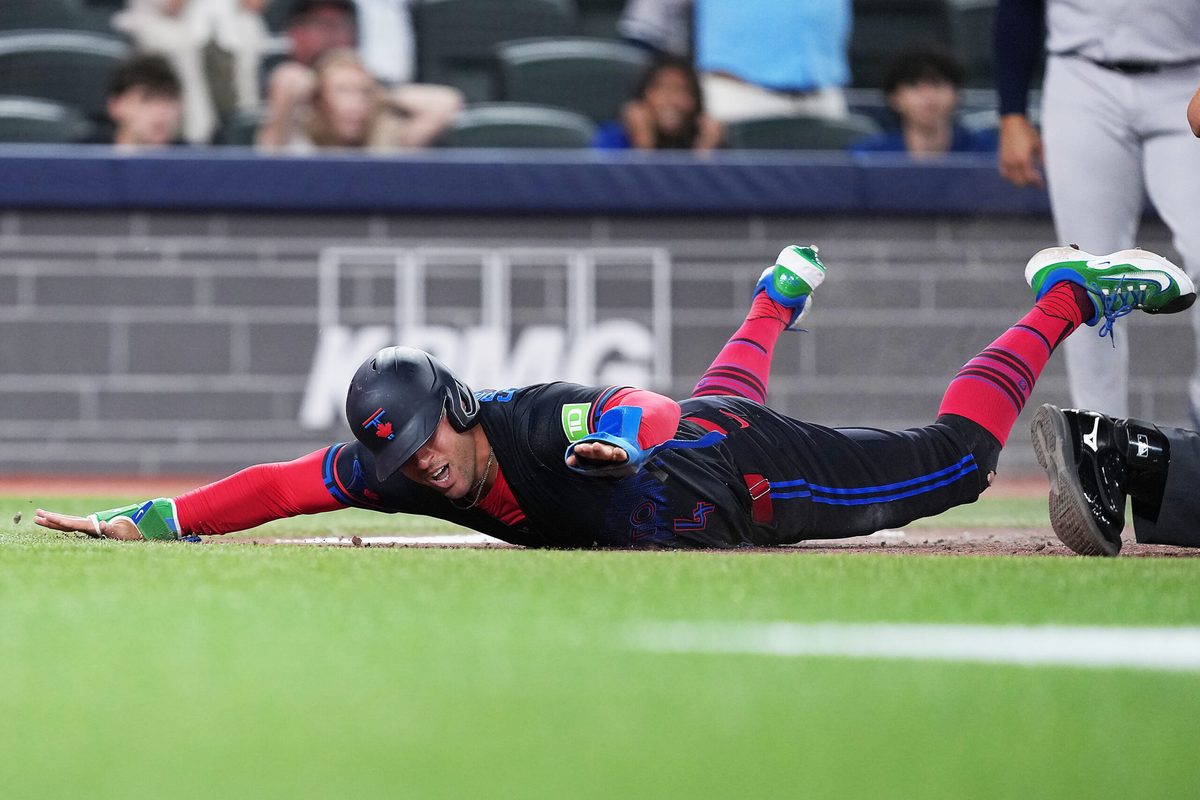 Jun 12, 2026; Toronto, Ontario, CAN; Toronto Blue Jays designated hitter George Springer (4) slides into home safe against the New York Yankees during the eighth inning at Rogers Centre. Mandatory Credit: Nick Turchiaro-Imagn Images