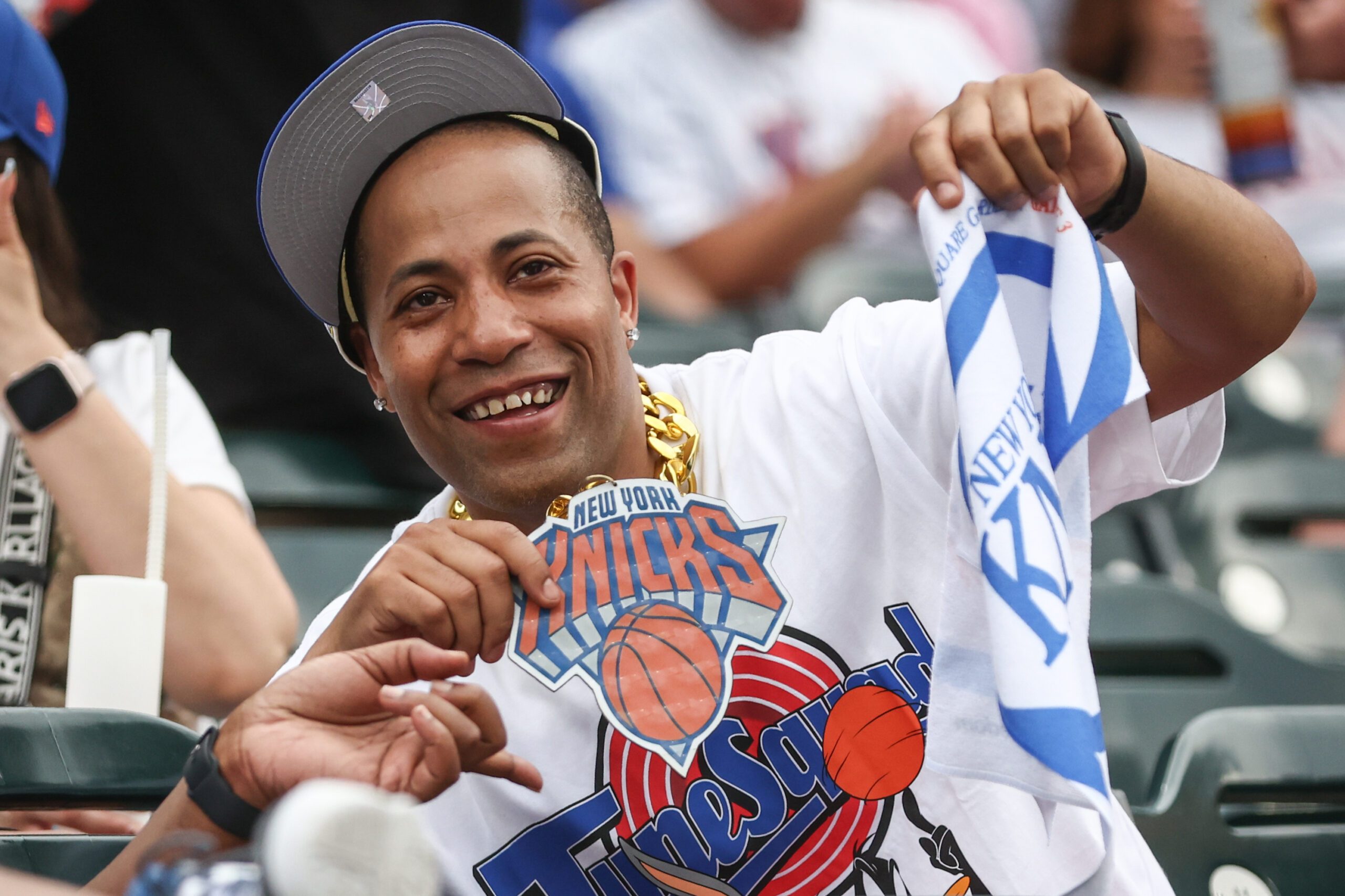 Jun 14, 2026; New York City, New York, USA;  A fan at the game between the Atlanta Braves and New York Mets celebrates the New York Knicks winning the NBA Finals at Citi Field. Mandatory Credit: Wendell Cruz-Imagn Images