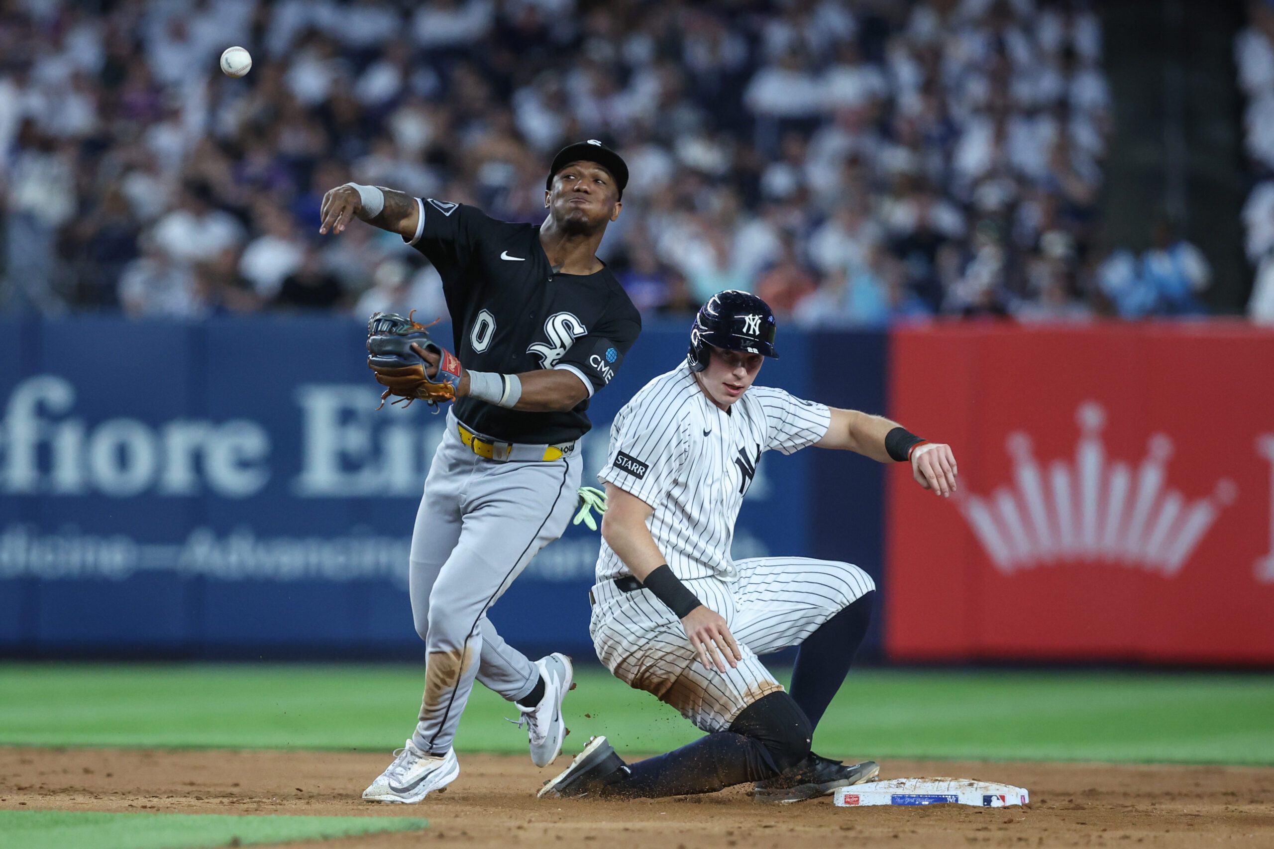 Jun 18, 2026; Bronx, New York, USA;  Chicago White Sox shortstop Luisangel Acuña (0) throws past New York Yankees first baseman Ben Rice (22) attempting to complete a double play in the sixth inning at Yankee Stadium. Mandatory Credit: Wendell Cruz-Imagn Images