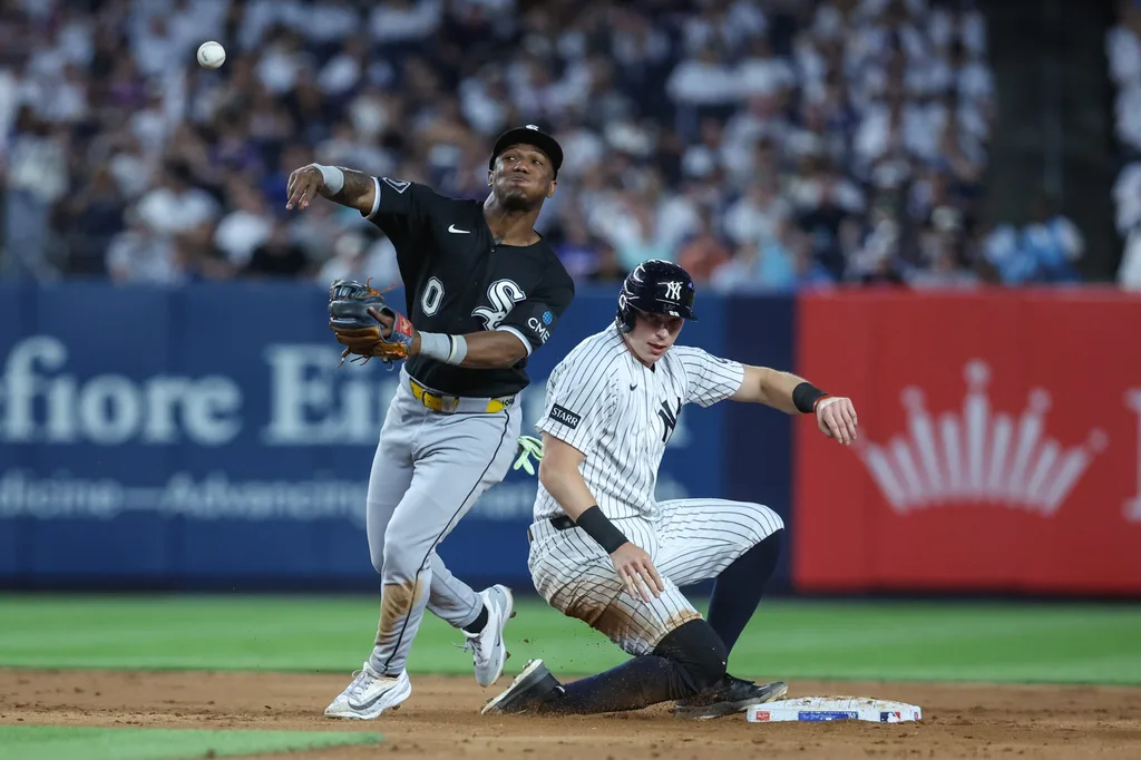 Jun 18, 2026; Bronx, New York, USA; Chicago White Sox shortstop Luisangel Acuña (0) throws past New York Yankees first baseman Ben Rice (22) attempting to complete a double play in the sixth inning at Yankee Stadium. Mandatory Credit: Wendell Cruz-Imagn Images