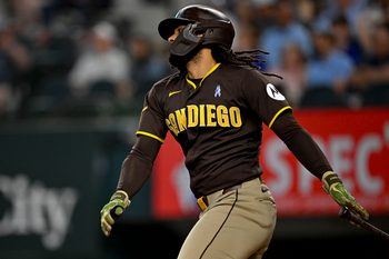 Jun 21, 2026; Arlington, Texas, USA; San Diego Padres pinch hitter Fernando Tatis Jr. (23) hits a single against the Texas Rangers during the ninth inning at Globe Life Field. Mandatory Credit: Jerome Miron-Imagn Images