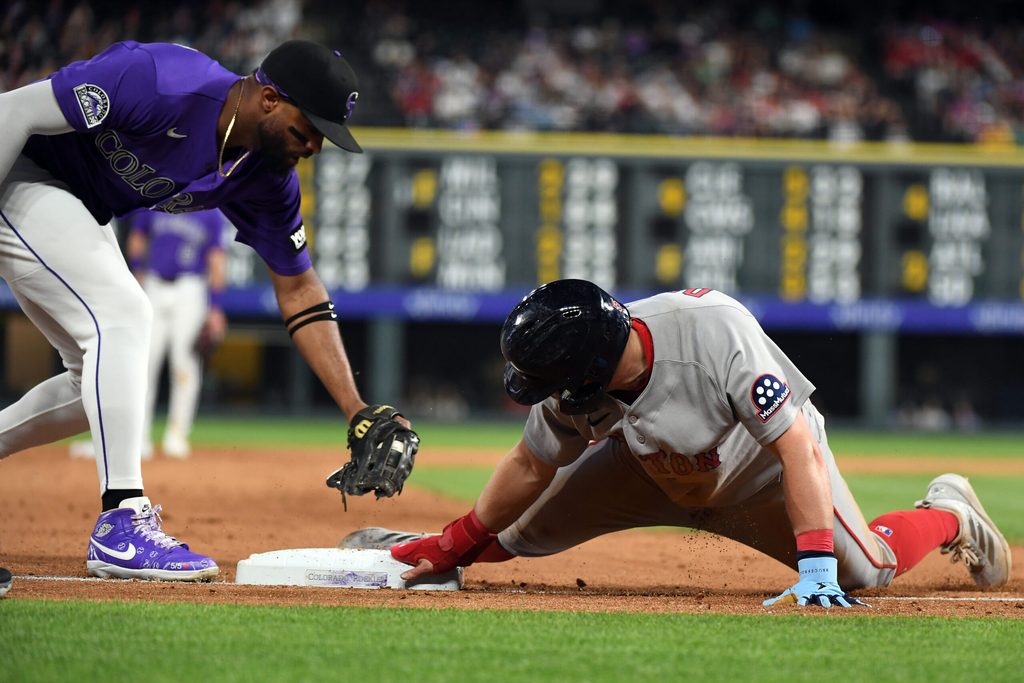 Jun 22, 2026; Denver, Colorado, USA; Boston Red Sox infielder Caleb Durbin (5) slides safely into third base ahead of a tag by Colorado Rockies outfielder Willi Castro (3) in the ninth inning at Coors Field. Mandatory Credit: Christopher Hanewinckel-Imagn Images