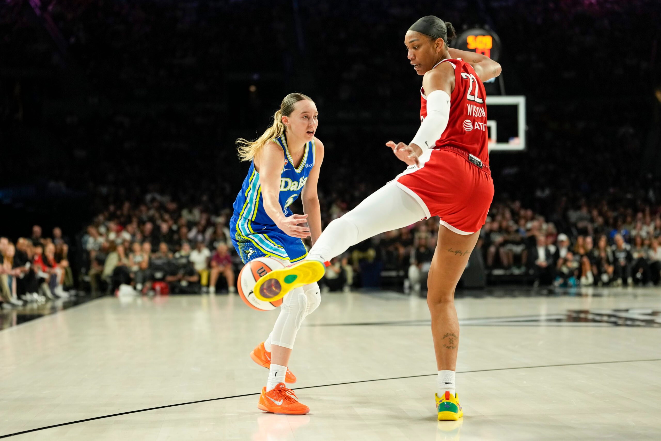 Jun 25, 2026; Las Vegas, Nevada, USA; Las Vegas Aces center A'ja Wilson (22) kicks a pass from Dallas Wings guard Paige Bueckers (5) during the third quarter of a WNBA basketball game at Michelob Ultra Arena. Mandatory Credit: Lucas Peltier-Imagn Images