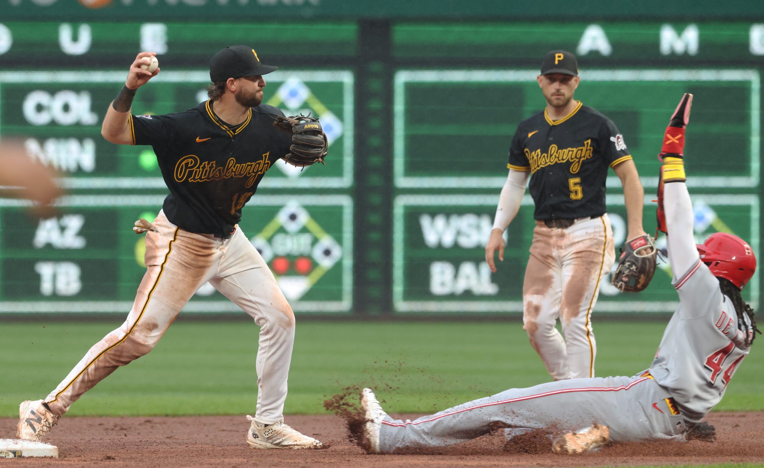 Jun 27, 2026; Pittsburgh, Pennsylvania, USA;  Pittsburgh Pirates shortstop Jared Triolo (19) turns a double play over Cincinnati Reds shortstop Elly de la Cruz (44) during the ninth inning at PNC Park. Mandatory Credit: Charles LeClaire-Imagn Images