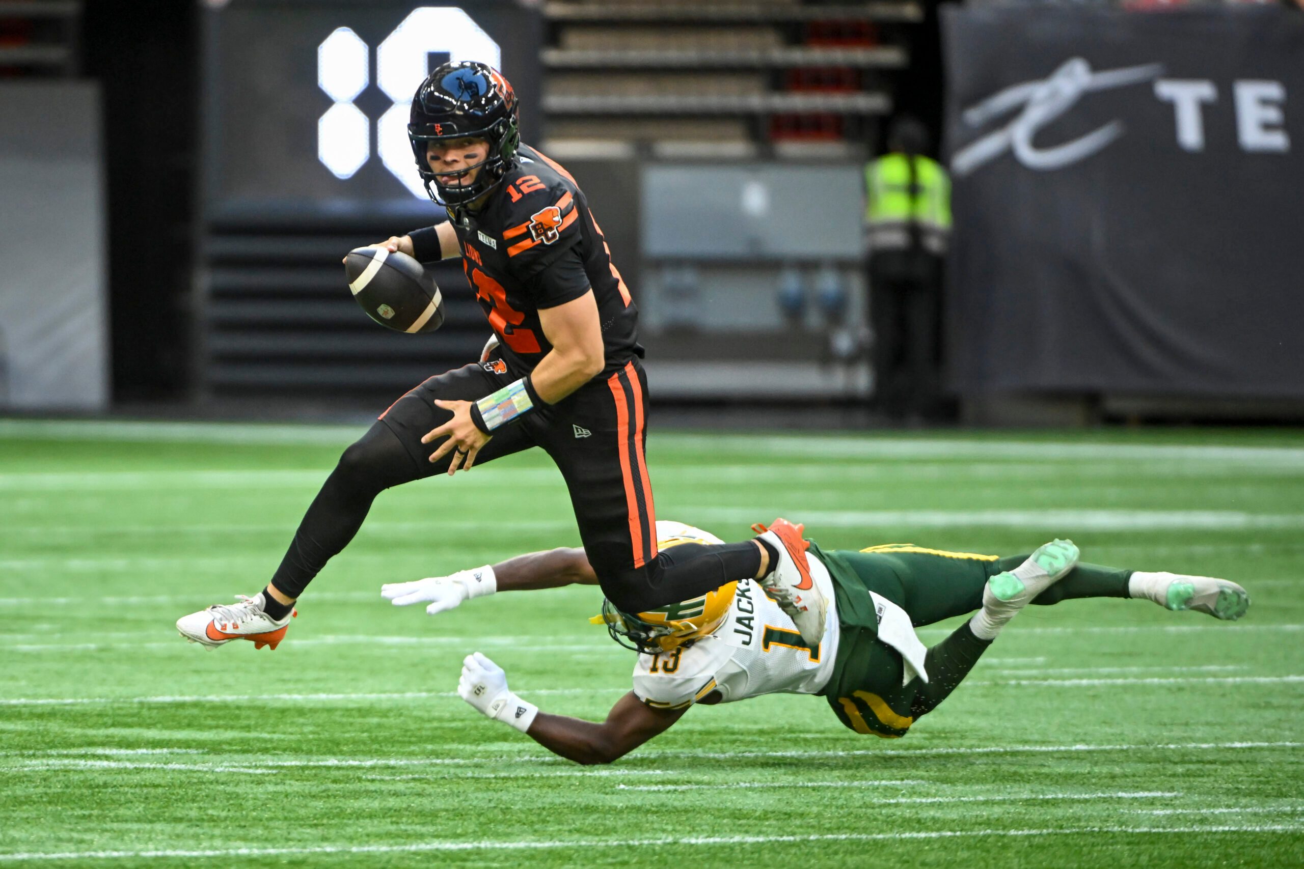 Jun 7, 2025; Vancouver, British Columbia, Canada;  BC Lions quarterback Nathan Rourke (12) runs the ball defended by Edmonton Elks defensive back Kordell Jackson (13) at BC Place Stadium. Mandatory Credit: Anne-Marie Sorvin-Imagn Images
