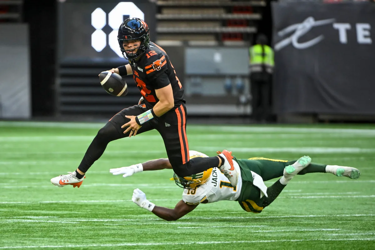 Jun 7, 2025; Vancouver, British Columbia, Canada; BC Lions quarterback Nathan Rourke (12) runs the ball defended by Edmonton Elks defensive back Kordell Jackson (13) at BC Place Stadium. Mandatory Credit: Anne-Marie Sorvin-Imagn Images