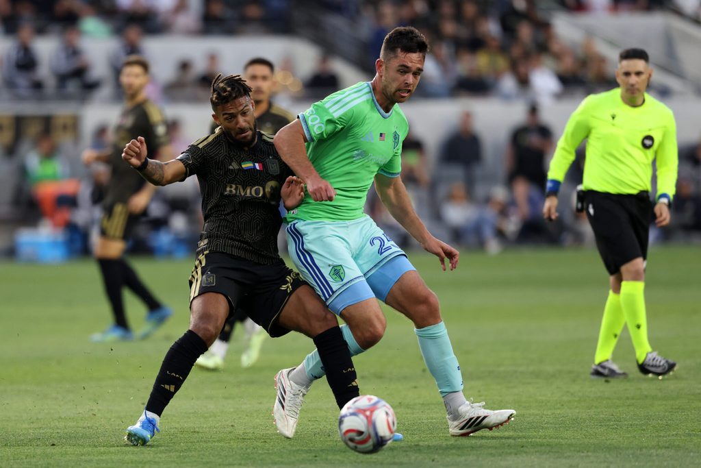 May 24, 2026; Los Angeles, California, USA; LAFC forward Denis Bouanga (99) and Seattle Sounders FC defender Jackson Ragen (25) fight for the ball during the second half at BMO Stadium. Mandatory Credit: Kiyoshi Mio-Imagn Images