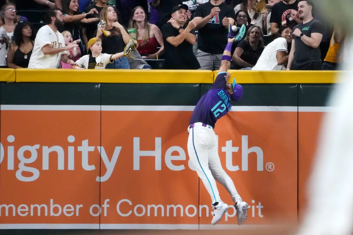 Arizona Diamondbacks outfielder Lourdes Gurriel Jr. (12) leaps to make a catch above the left field wall against the Milwaukee Brewers at Chase Field in Phoenix, on July 3, 2026.