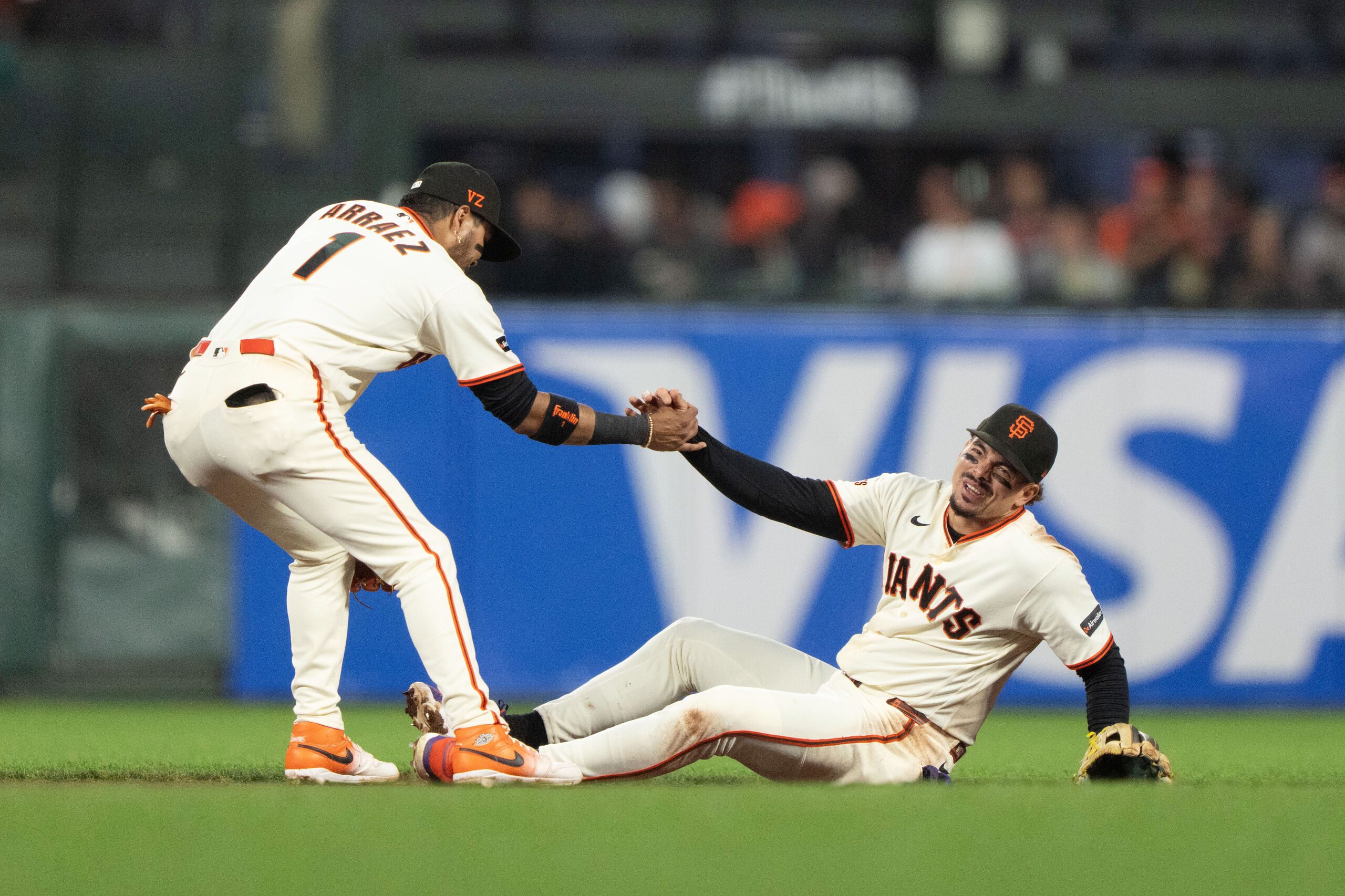 Jul 9, 2026; San Francisco, California, USA;  San Francisco Giants second baseman Luis Arraez (1) helps shortstop Willy Adames (2) during the seventh inning against the Colorado Rockies at Oracle Park. Mandatory Credit: Stan Szeto-Imagn Images