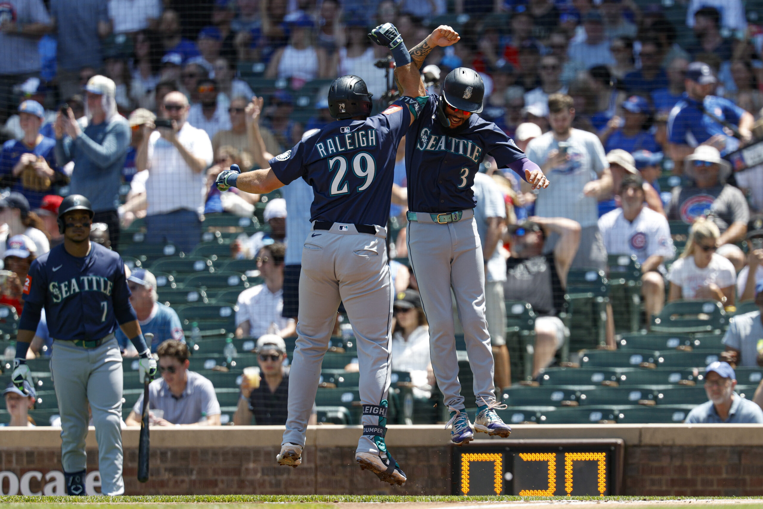 Jun 22, 2025; Chicago, Illinois, USA; Seattle Mariners designated hitter Cal Raleigh (29) celebrates with shortstop J.P. Crawford (3) after hitting a two-run home run against the Chicago Cubs during the first inning at Wrigley Field. Mandatory Credit: Kamil Krzaczynski-Imagn Images
