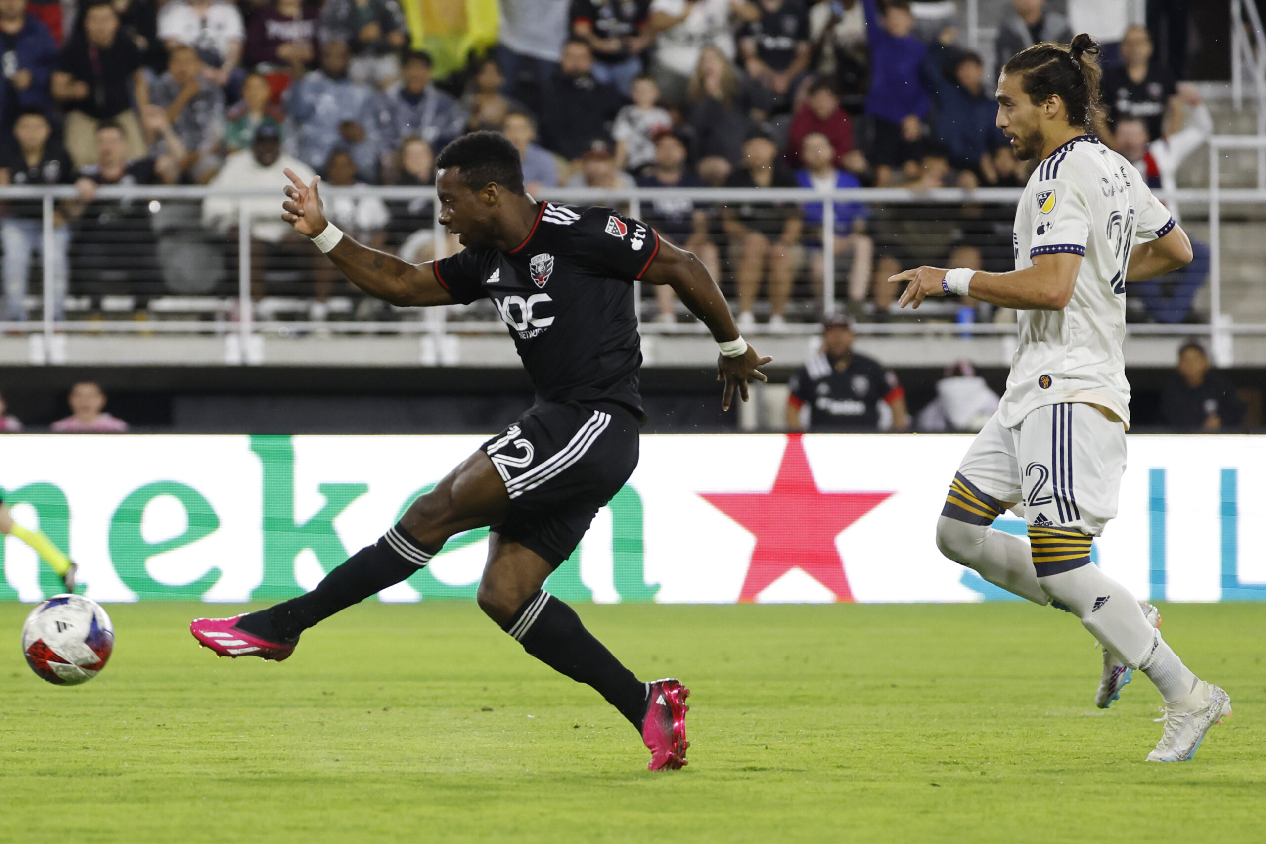 May 20, 2023; Washington, District of Columbia, USA; D.C. United forward Cristi n D jome (12) scores a goal as LA Galaxy defender Mart n C ceres (22) looks on in the second half at Audi Field. Mandatory Credit: Geoff Burke-Imagn Images