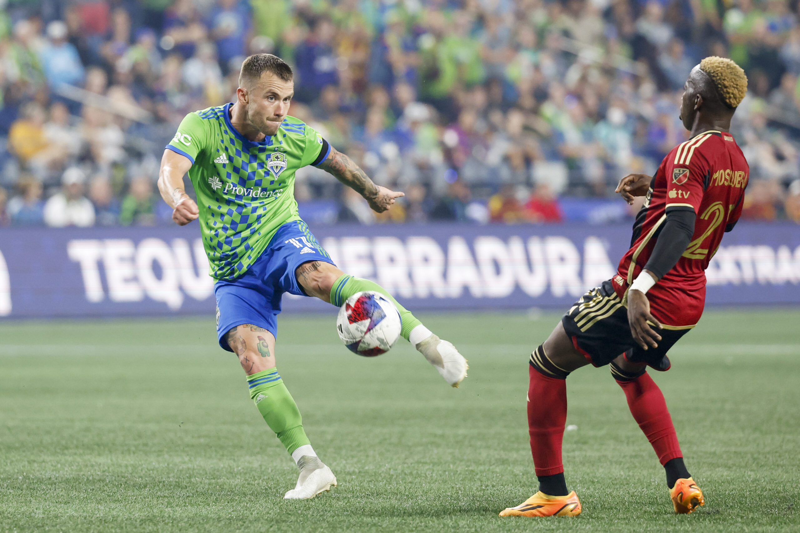 Aug 20, 2023; Seattle, Washington, USA; Seattle Sounders FC midfielder Albert Rusnak (11) shoots a deflection before Atlanta United midfielder Edwin Mosquera (21) can reach it during the second half at Lumen Field. Mandatory Credit: Joe Nicholson-Imagn Images
