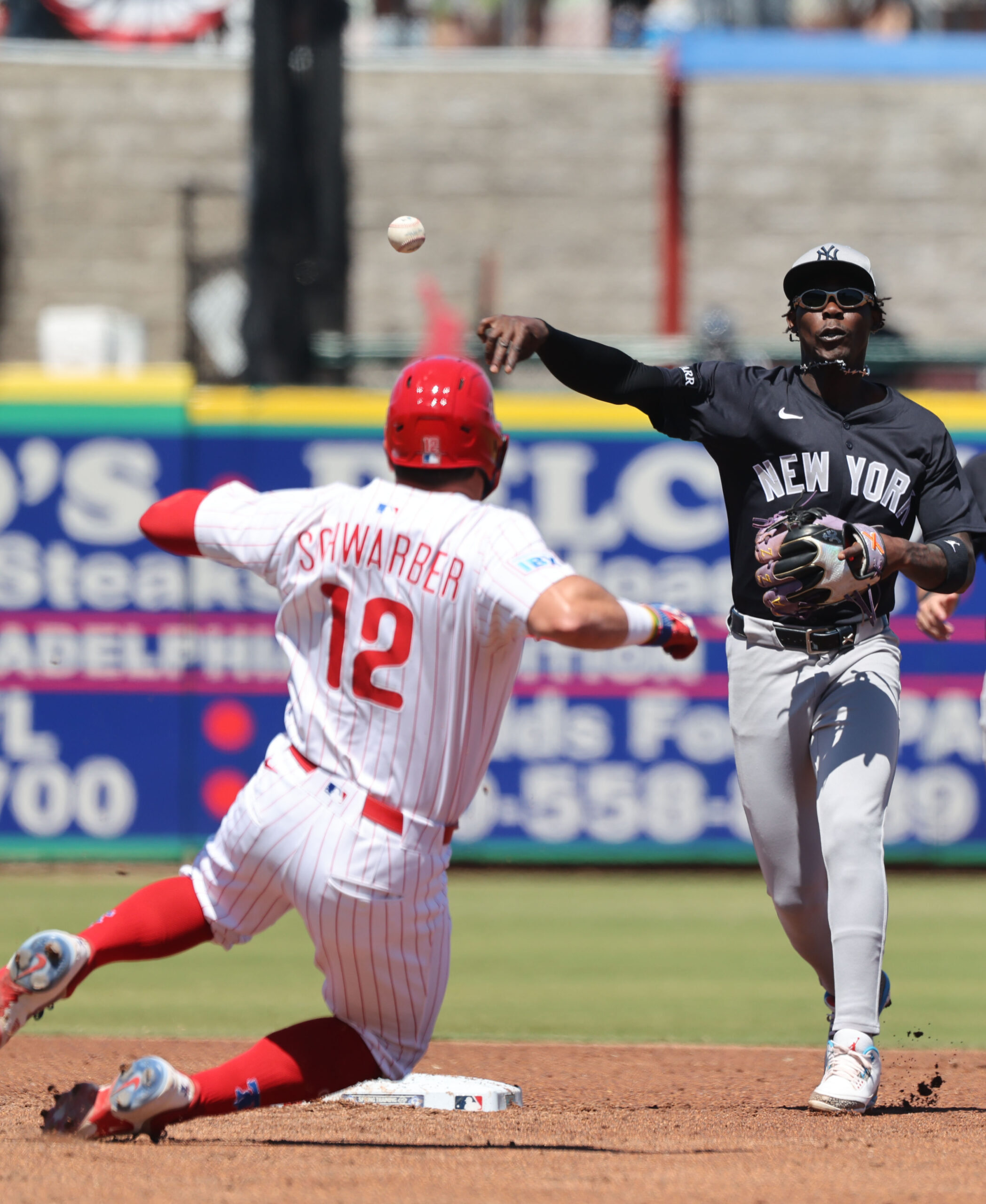 Mar 19, 2025; Clearwater, Florida, USA; New York Yankees third base Jazz Chisholm Jr. (13) forces out Philadelphia Phillies designated hitter Kyle Schwarber (12) and throws the ball to first base for a double play during the third inning at BayCare Ballpark. Mandatory Credit: Kim Klement Neitzel-Imagn Images