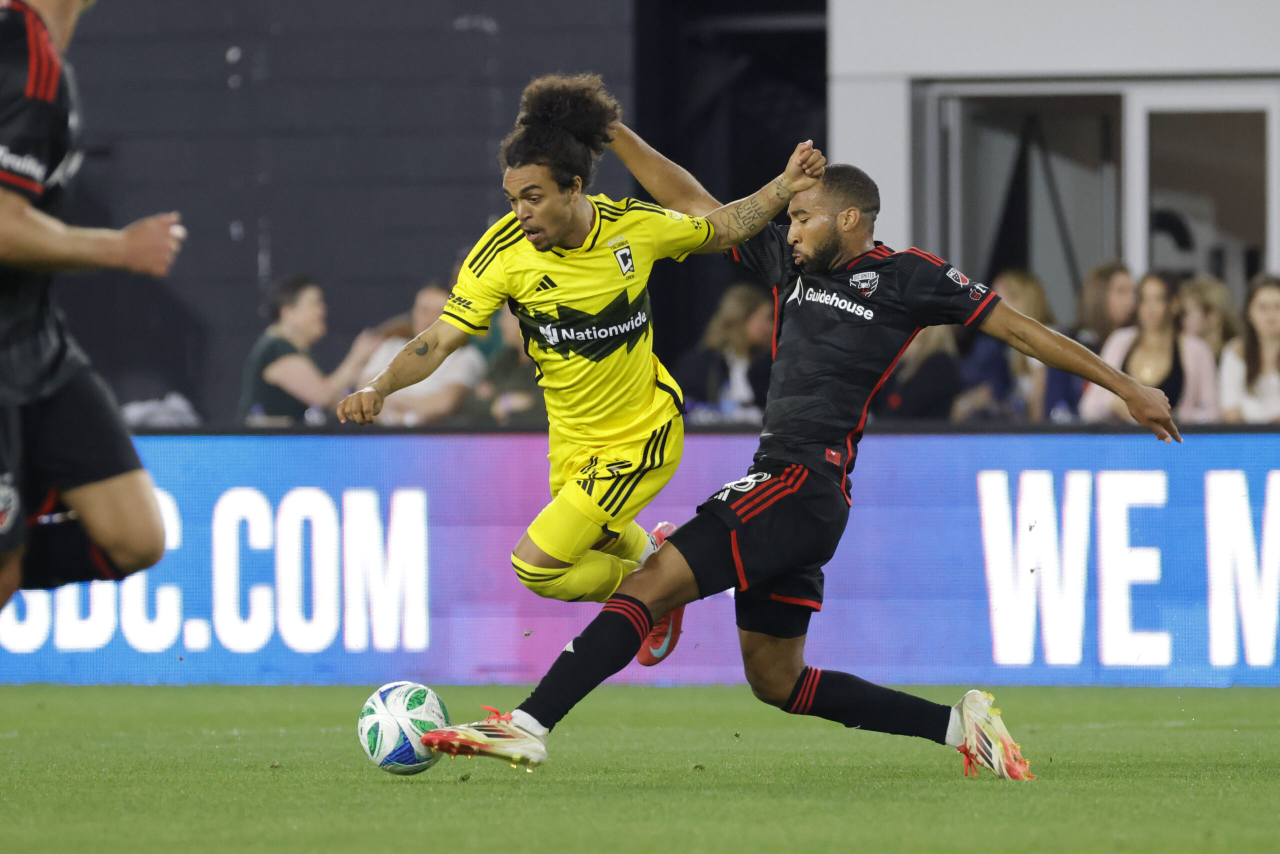Mar 29, 2025; Washington, District of Columbia, USA; Columbus Crew midfielder Aziel Jackson (13) and D.C. United defender Derek Dodson (18) battle for the ball during the second half at Audi Field. Mandatory Credit: Amber Searls-Imagn Images