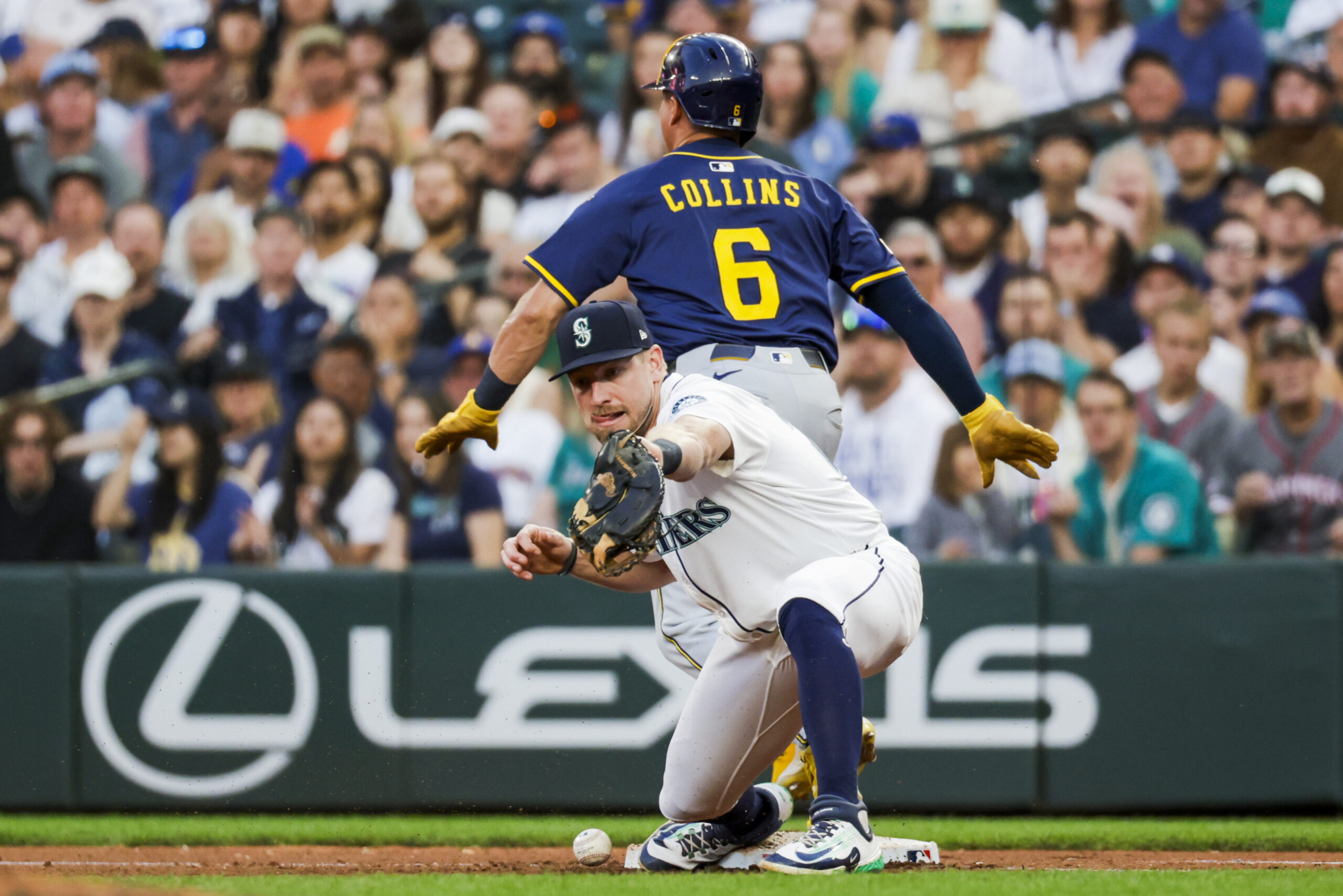 Jul 22, 2025; Seattle, Washington, USA; Seattle Mariners first baseman Luke Raley (20) drops a throw allowing Milwaukee Brewers right fielder Isaac Collins (6) safe during the seventh inning at T-Mobile Park. Mandatory Credit: Joe Nicholson-Imagn Images