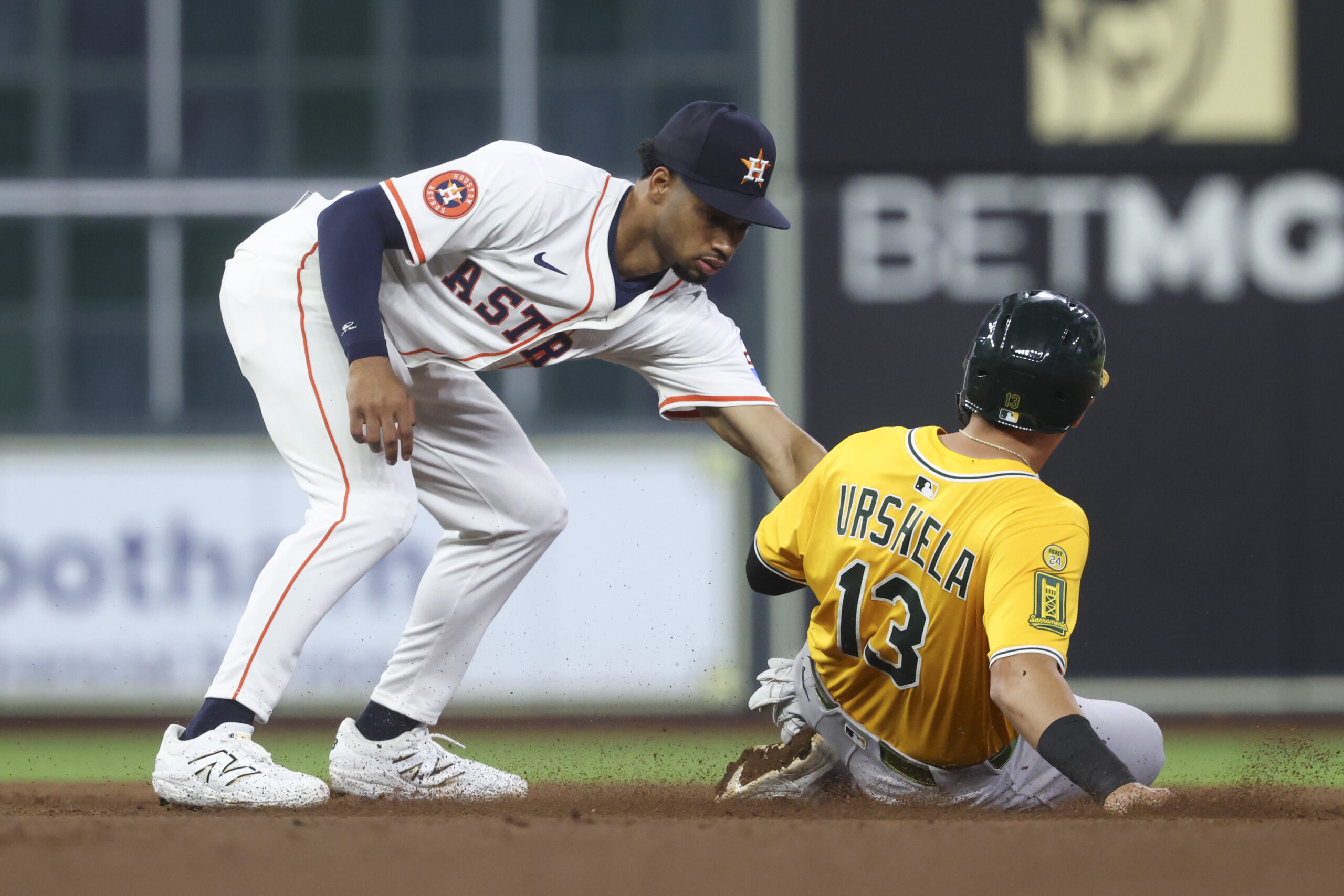 Jul 24, 2025; Houston, Texas, USA; Athletics third baseman Gio Urshela (13) is out on a stolen base attempt as Houston Astros second baseman Brice Matthews (28) applies a tag during the eighth inning at Daikin Park. Mandatory Credit: Troy Taormina-Imagn Images