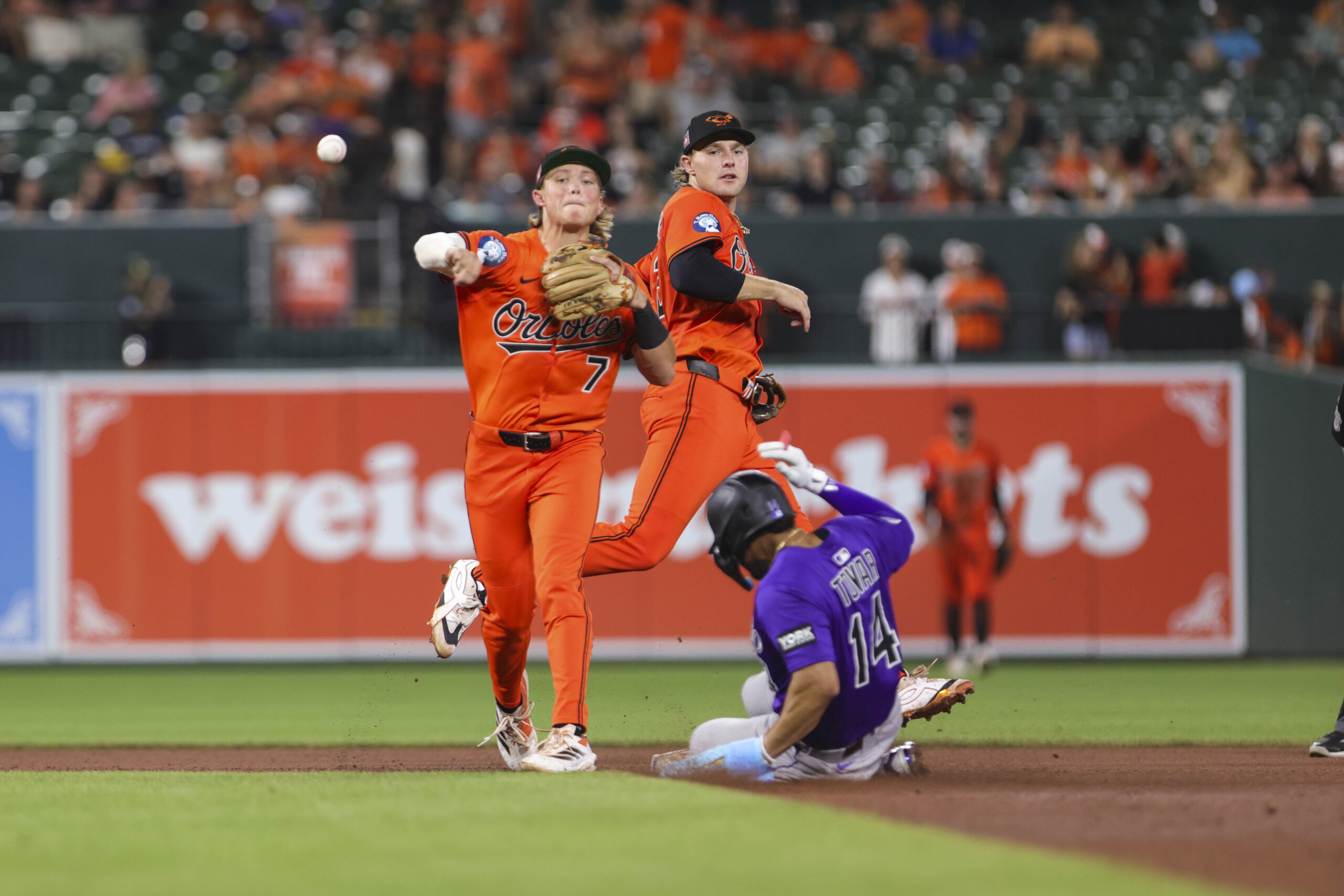 Jul 26, 2025; Baltimore, Maryland, USA; Baltimore Orioles’ second Baseman Jackson Holliday (7) turns a double play against the Colorado Rockies in the seventh inning at Oriole Park at Camden Yards. Mandatory Credit: Lexi Thompson-Imagn Images