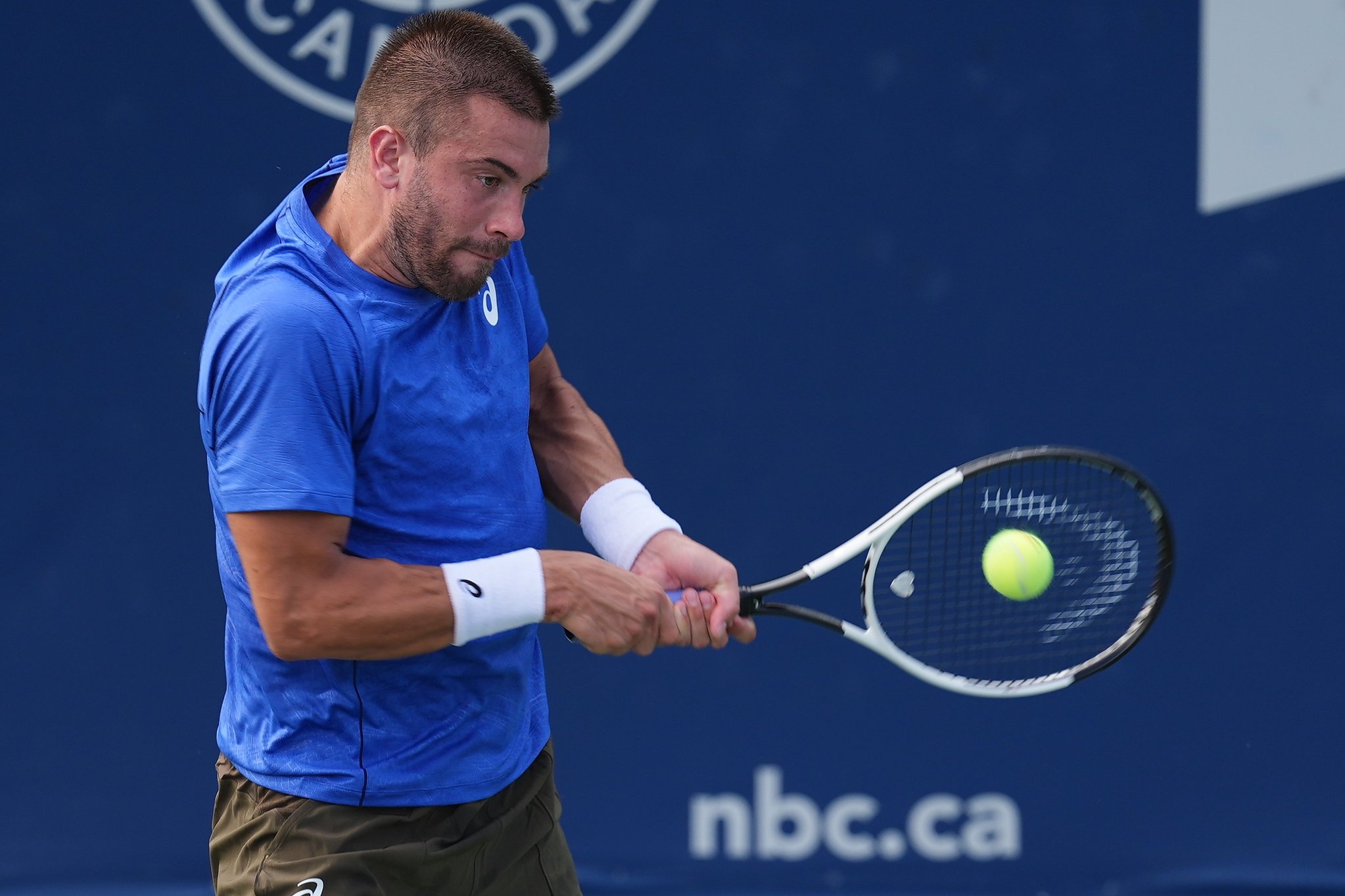 Jul 28, 2025; Toronto, ON, Canada; Borna Coric (CRO) hits a ball to Matteo Gigante (not pictured) during first round play at Sobeys Stadium. Mandatory Credit: John E. Sokolowski-Imagn Images