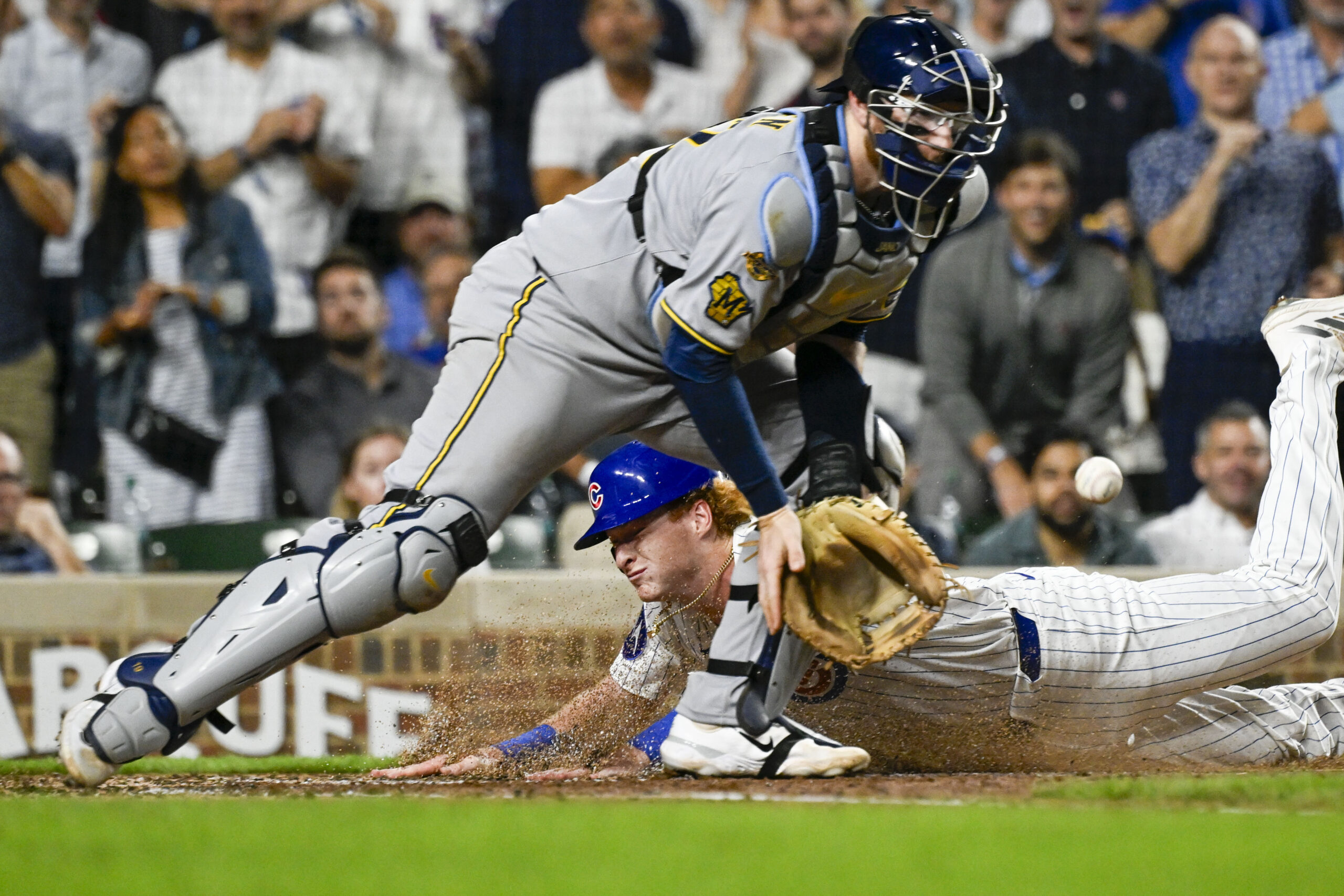 Aug 19, 2025; Chicago, Illinois, USA;  Chicago Cubs outfielder Owen Caissie (19) scores past Milwaukee Brewers catcher Danny  Jansen (33) during the second inning at Wrigley Field. Mandatory Credit: Matt Marton-Imagn Images