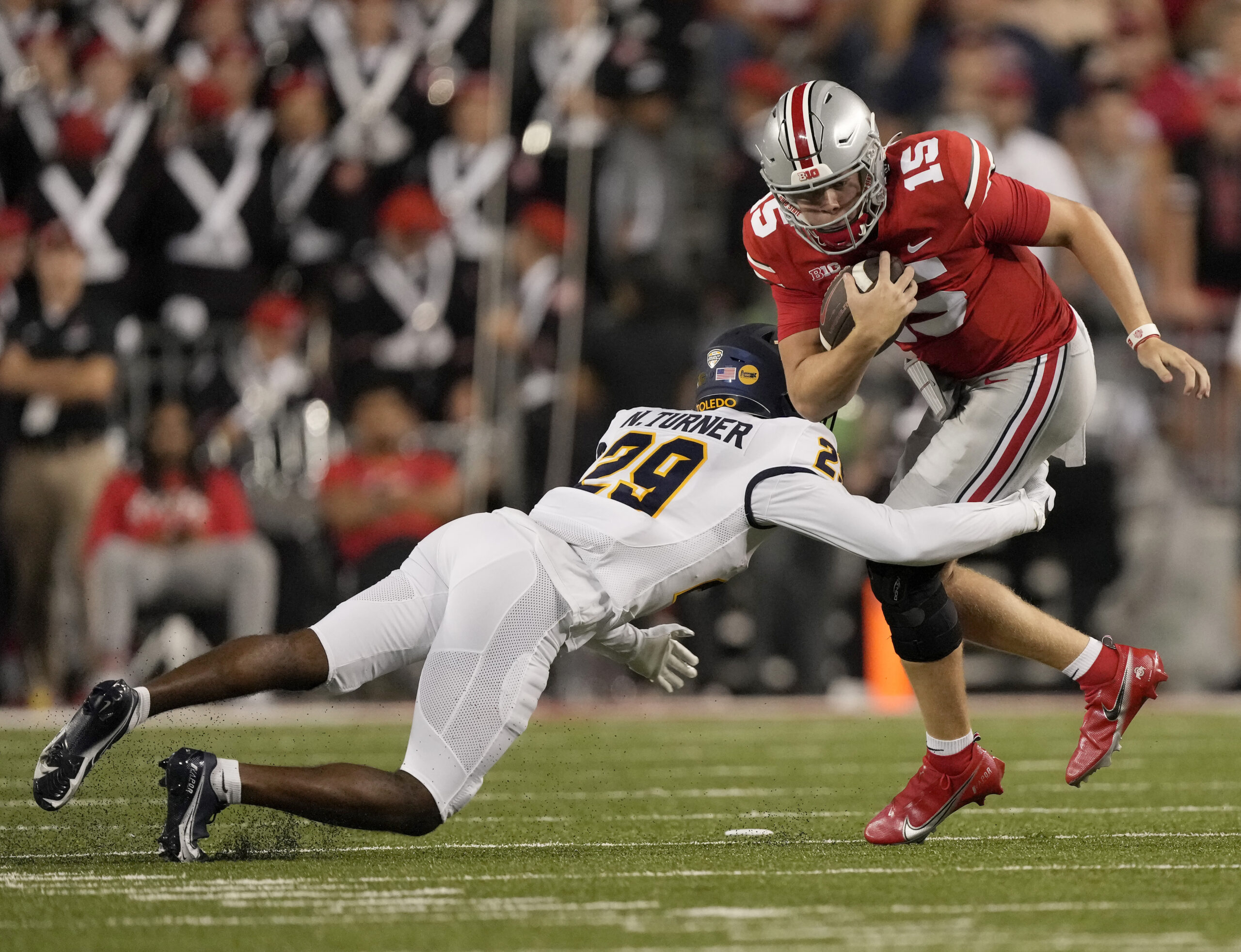 Sep 17, 2022; Columbus, Ohio, USA; Ohio State Buckeyes quarterback Devin Brown (15) is tackled by Toledo Rockets cornerback Nick Turner (29) during a college football game at Ohio Stadium. Mandatory Credit: Barbara Perenic-Imagn Images