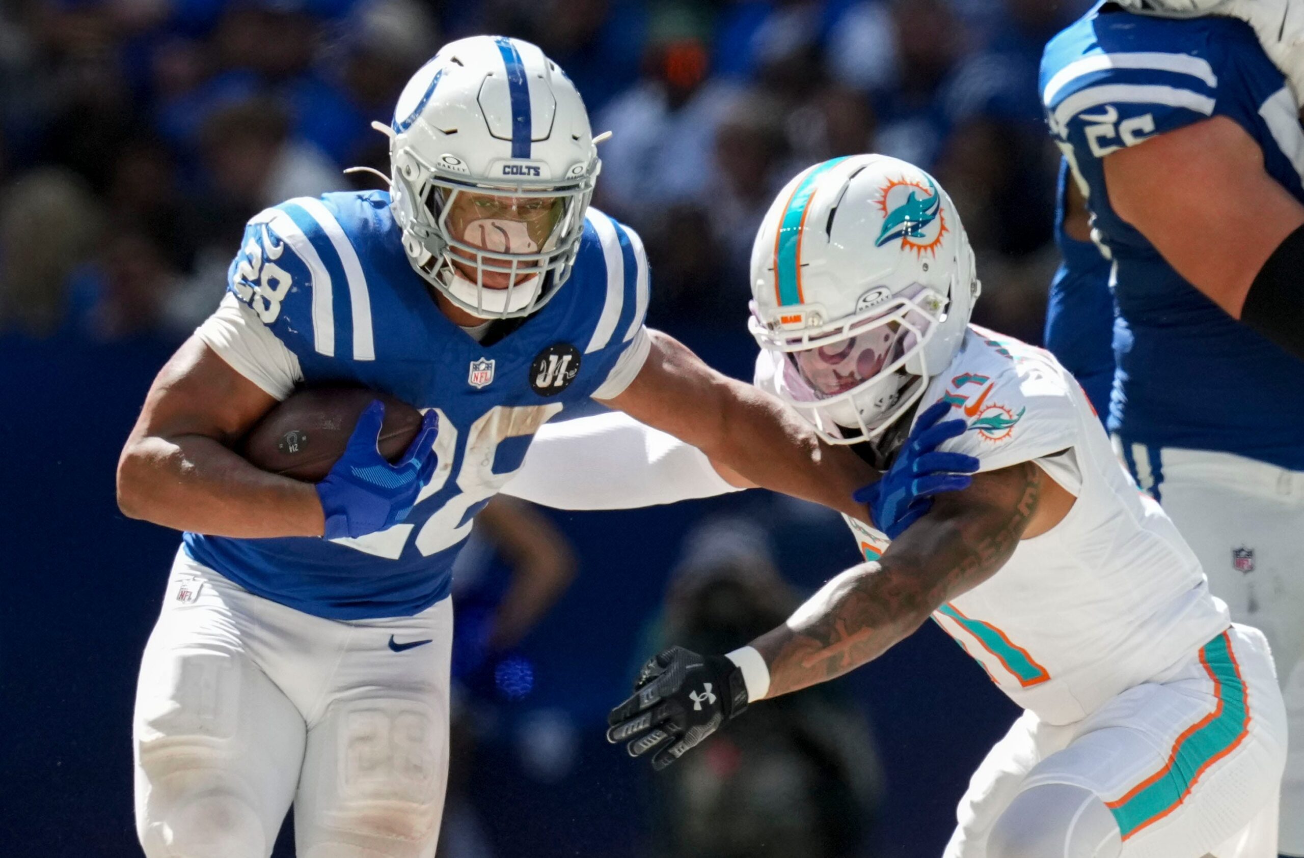 Sep 7, 2025; Indianapolis, Indiana, USA; Miami Dolphins safety Dante Trader Jr. (11) attempts to bring down Indianapolis Colts running back Jonathan Taylor (28) during the second half of a game  at Lucas Oil Stadium. Mandatory Credit: Christine Tannous-USA TODAY Network via Imagn Images