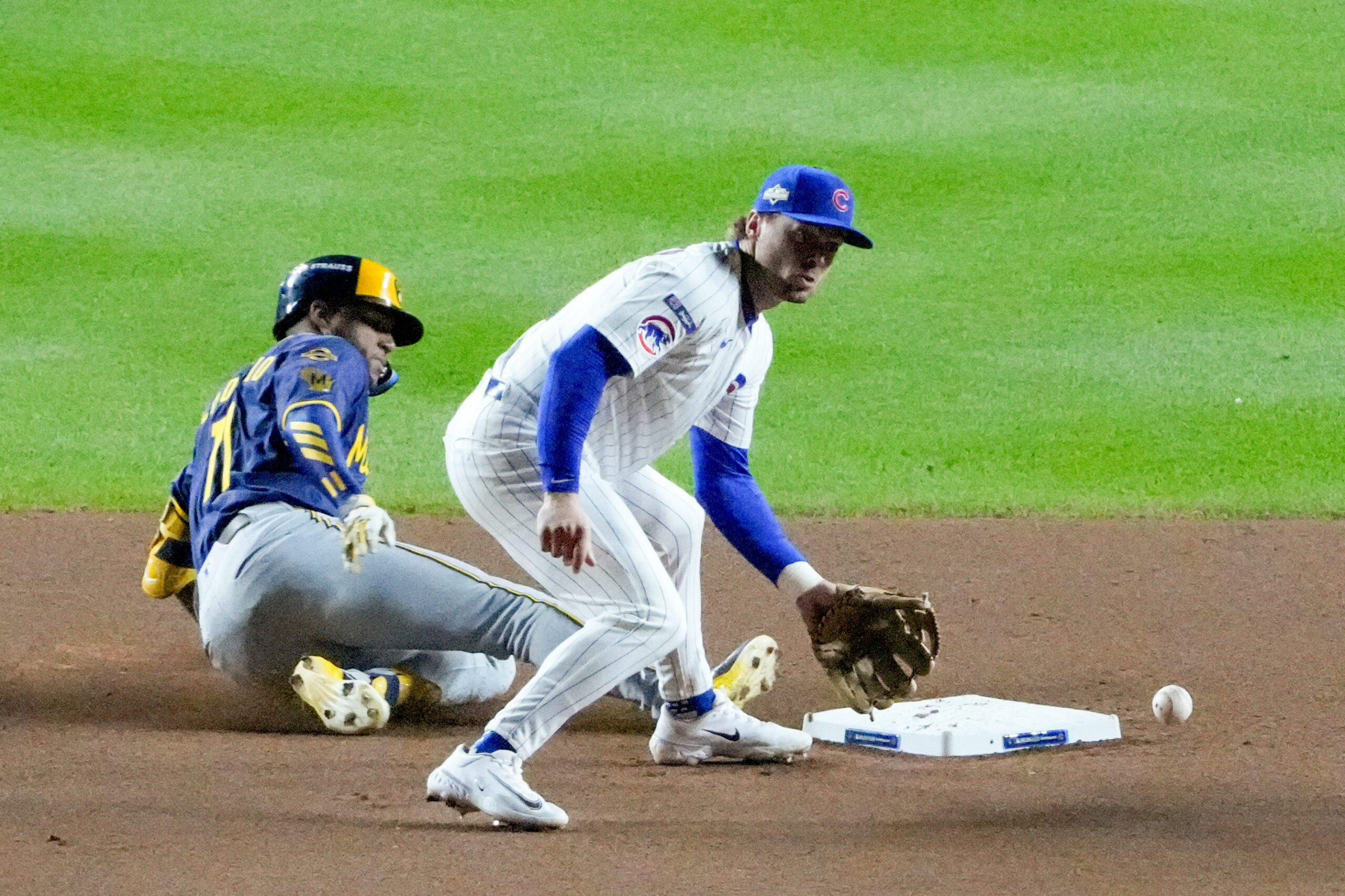 Oct 8, 2025; Chicago, Illinois, USA; Milwaukee Brewers center fielder Jackson Chourio (11) slides into second base safely with a double as Chicago Cubs second baseman Nico Hoerner (2) fields the throw in the eighth inning during game three of the NLDS round for the 2025 MLB playoffs at Wrigley Field. Mandatory Credit: David Banks-Imagn Images