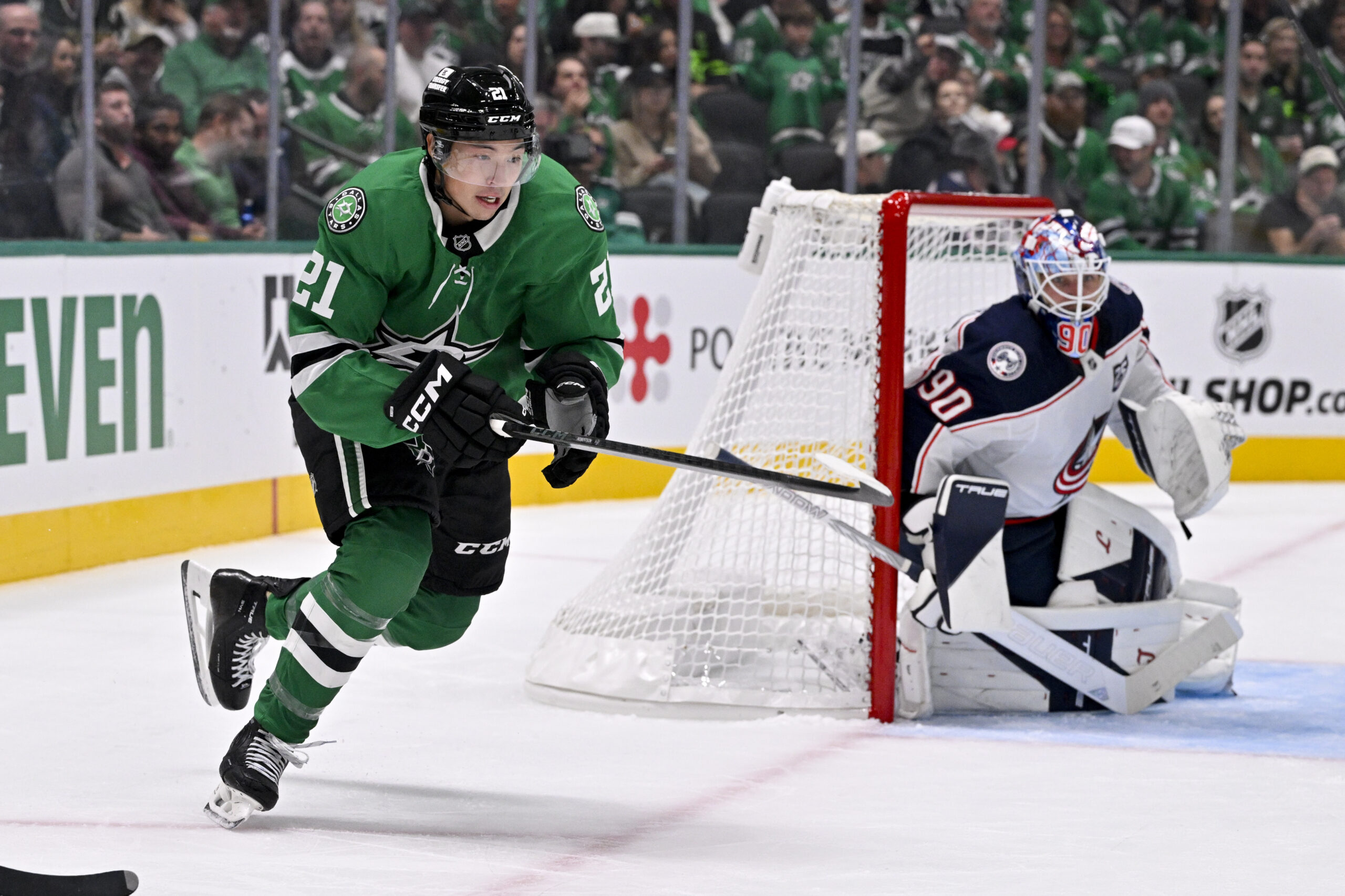 Oct 21, 2025; Dallas, Texas, USA; Dallas Stars left wing Jason Robertson (21) skates past Columbus Blue Jackets goaltender Elvis Merzlikins (90) during the game between the Stars and the Blue Jackets at the American Airlines Center. Mandatory Credit: Jerome Miron-Imagn Images