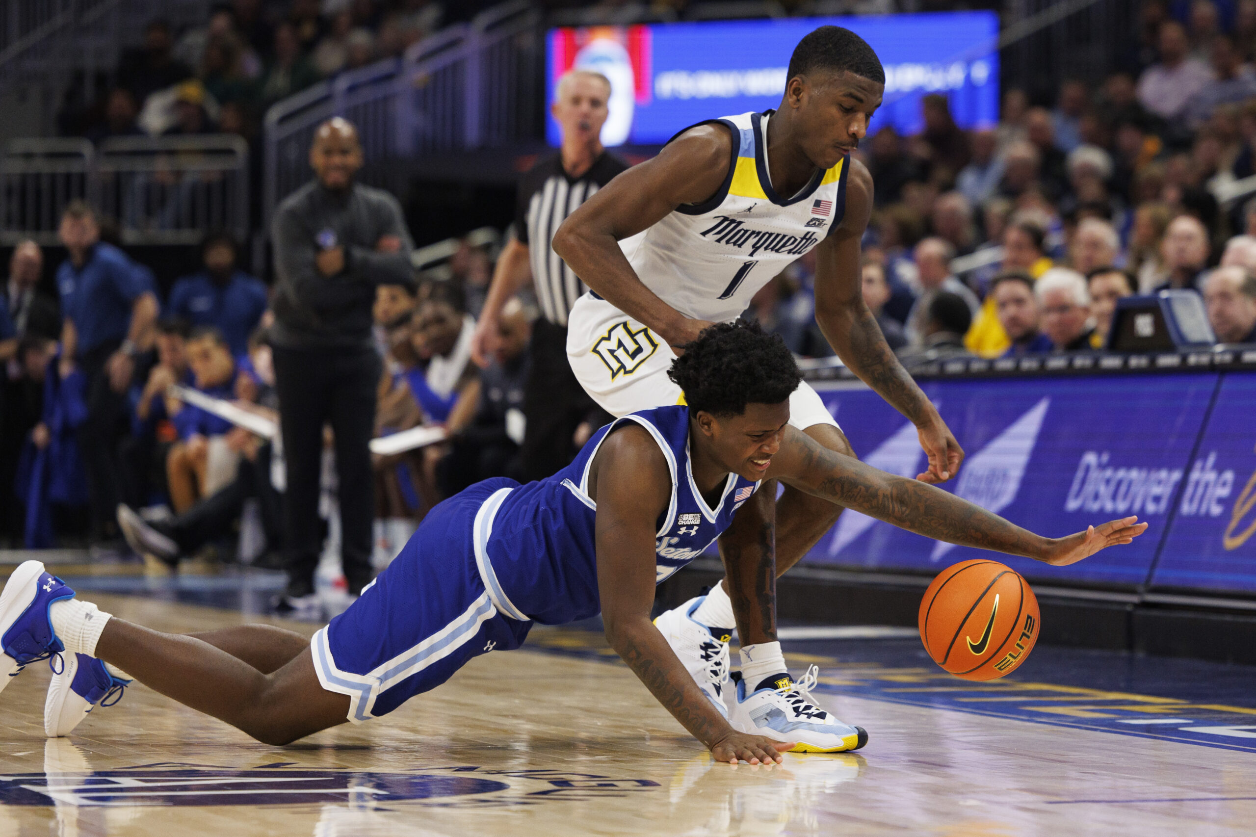 Dec 27, 2022; Milwaukee, Wisconsin, USA;  Seton Hall Pirates guard Jaquan Sanders (20) and Marquette Golden Eagles guard Kam Jones (1) chase the loose ball during the first half at Fiserv Forum. Mandatory Credit: Jeff Hanisch-Imagn Images