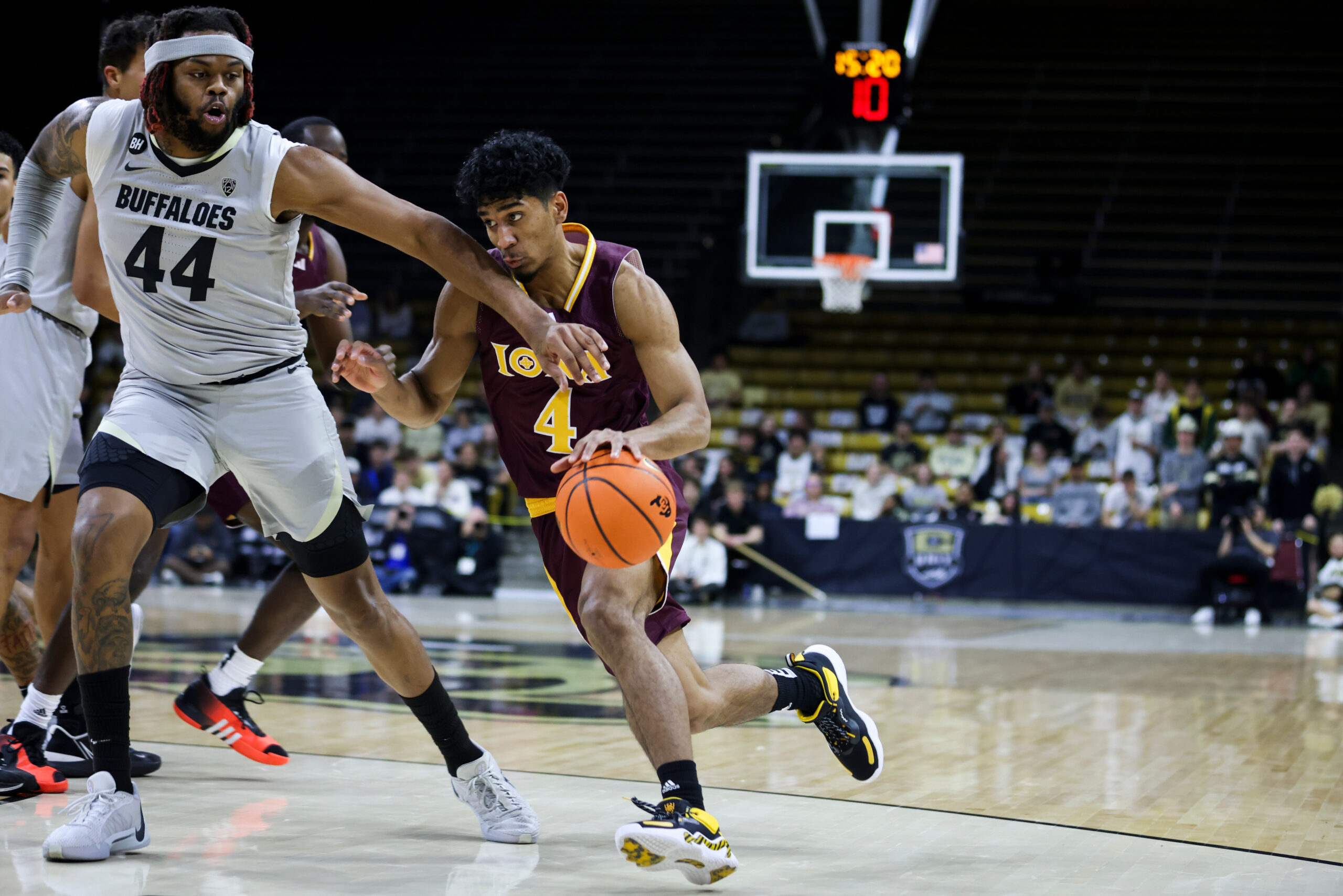 Nov 26, 2023; Boulder, Colorado, USA; Iona Gaels guard Jean Aranguren (4) drives past Colorado Buffaloes center Eddie Lampkin Jr. (44) in the first half at CU Events Center. Mandatory Credit: Chet Strange-Imagn Images